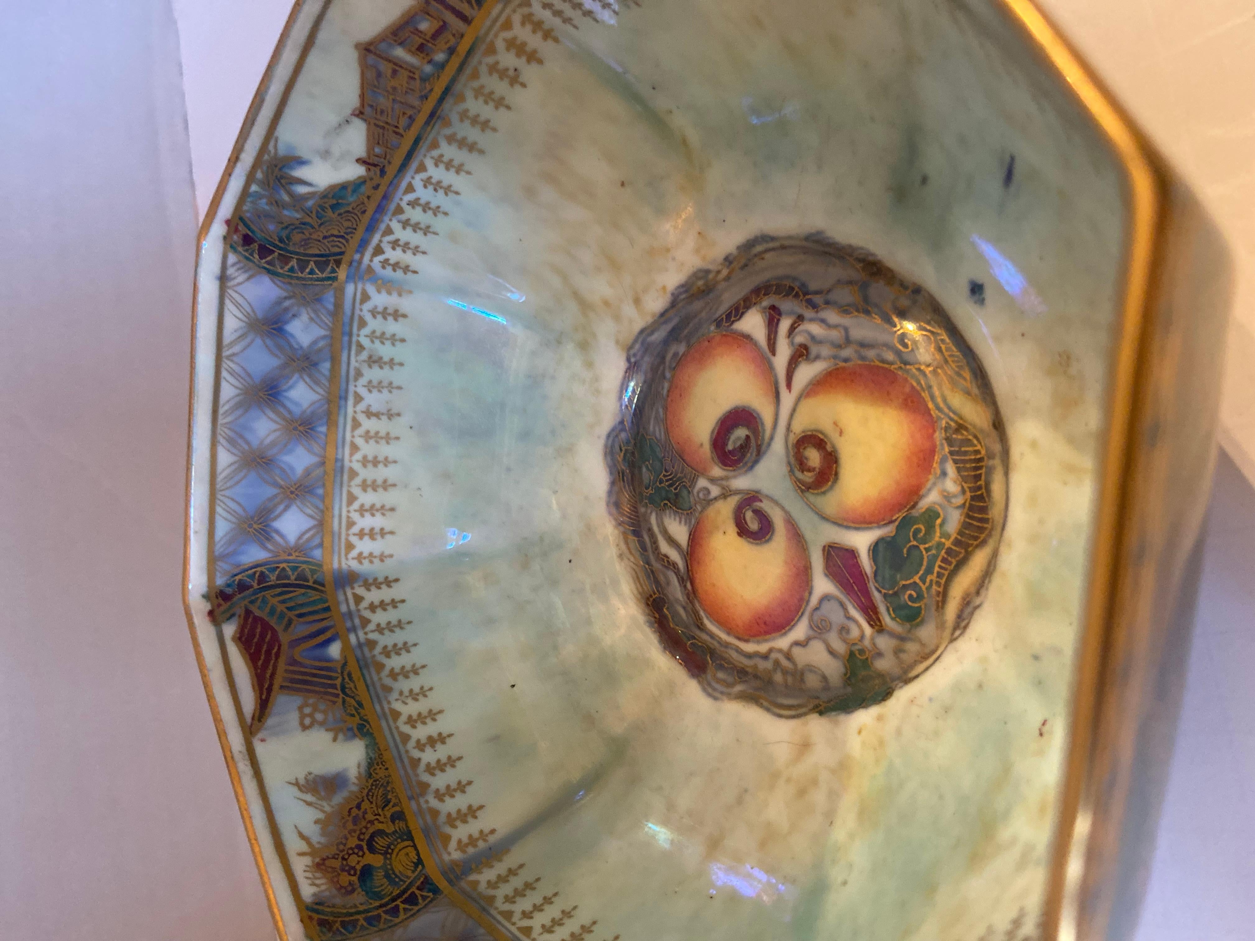 This rare and stunning bowl hand painted by Daisy Makeig Jones in the mid 1920’s retains its trademark lustre. The exterior of the bowl is a rich green with blue undertones. The interior is a pale blue with lavender and yellow. The gilt details are