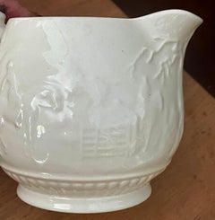 Crémier « Devonshire » de Wedgewood, couleur blanc cassé, à motifs classiques en relief, sur le thème de la chasse