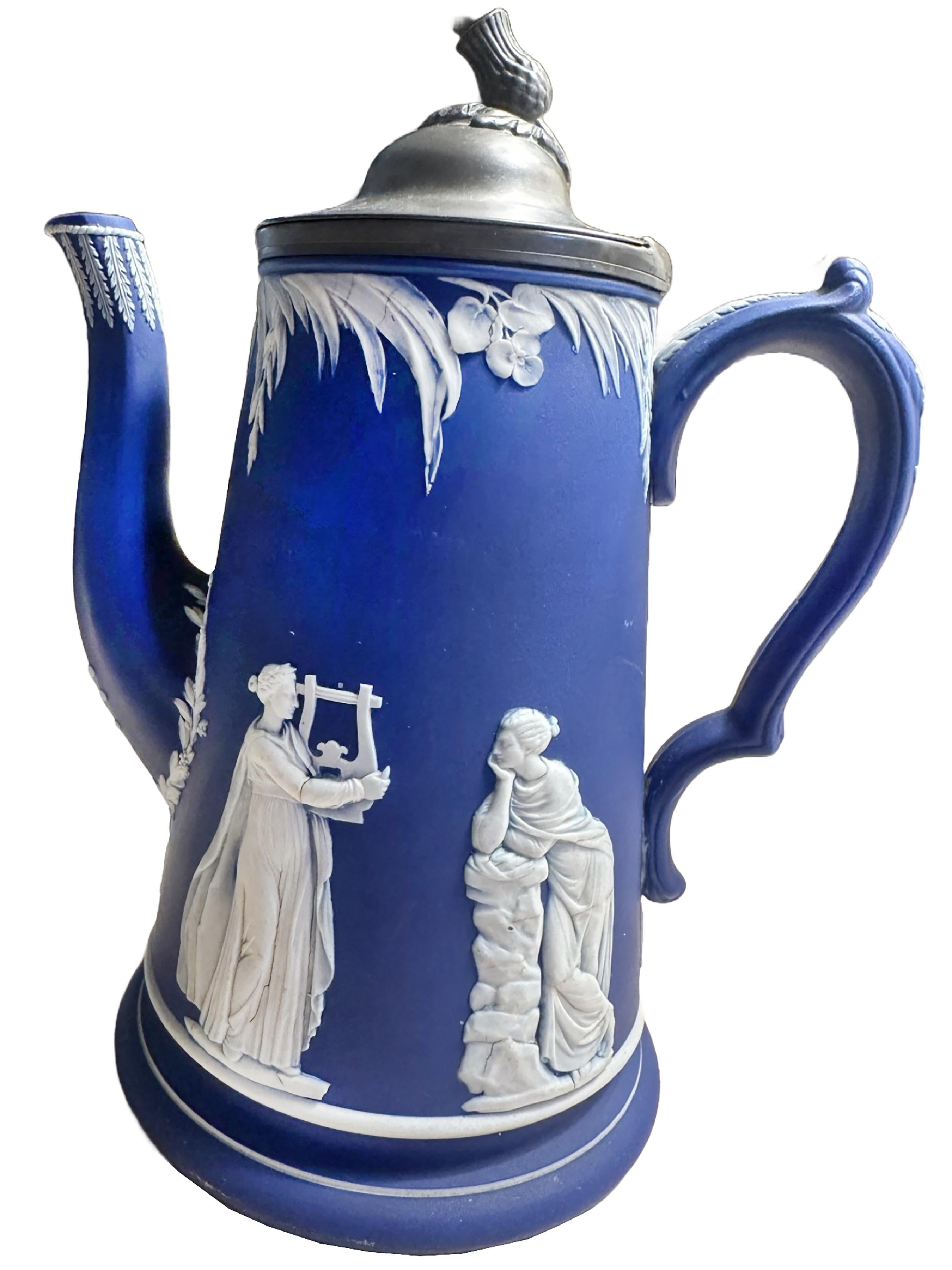 Una pregiata caffettiera in Jasperware bianca e blu di Wedgewood fatta a mano. Finali a cardo in argento Coperchio. I colori principali sono il blu e il bianco, con figure classiche su un lato che tengono la testa della gorgone e uno che tiene una