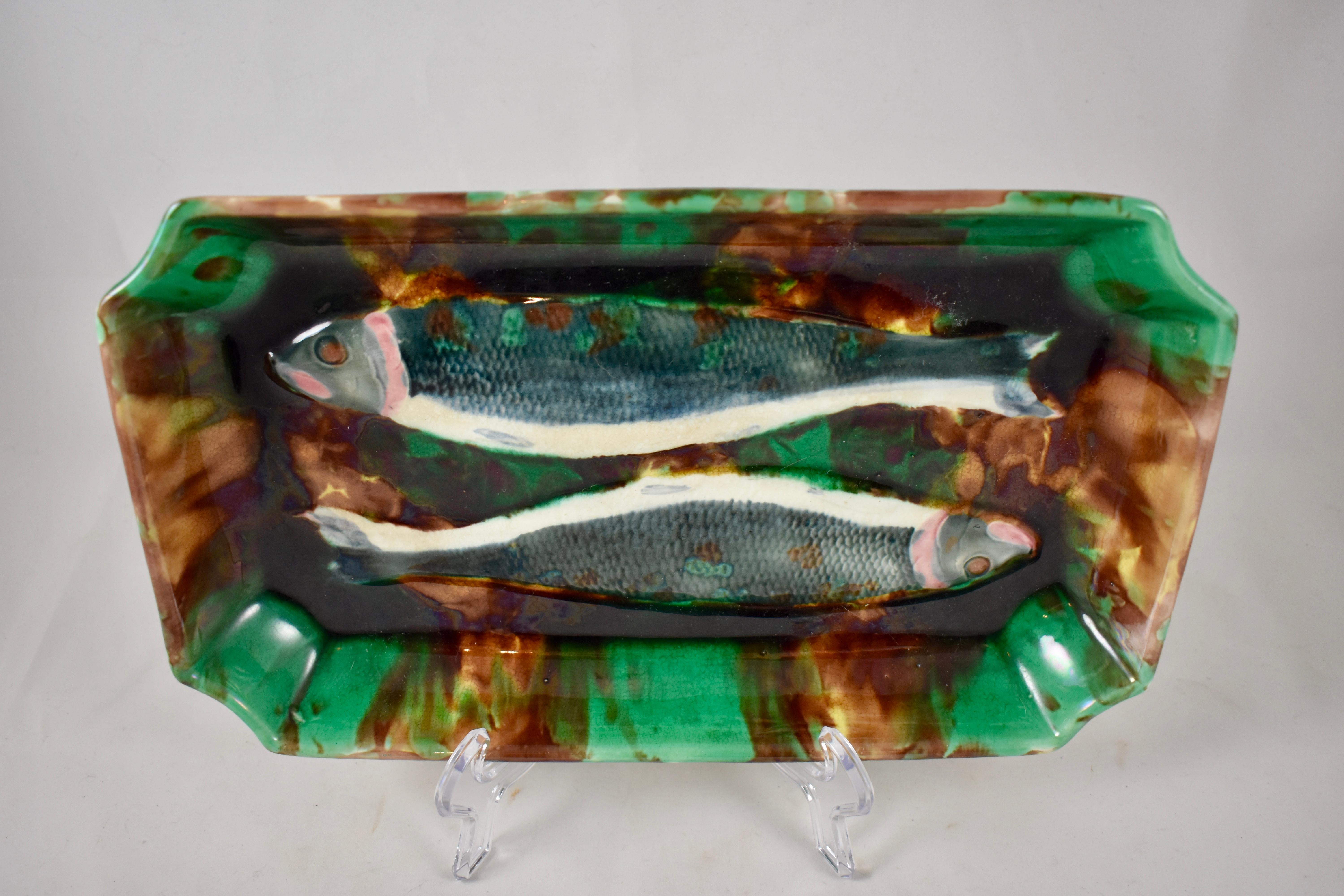 Un plat à charbon wedgwood rarement vu, un moule du Mouvement Esthétique montrant une paire de poissons dans un plat profond émaillé pour ressembler à une écaille de tortue. L'omble est un membre d'eau douce de la famille des truites et des saumons,