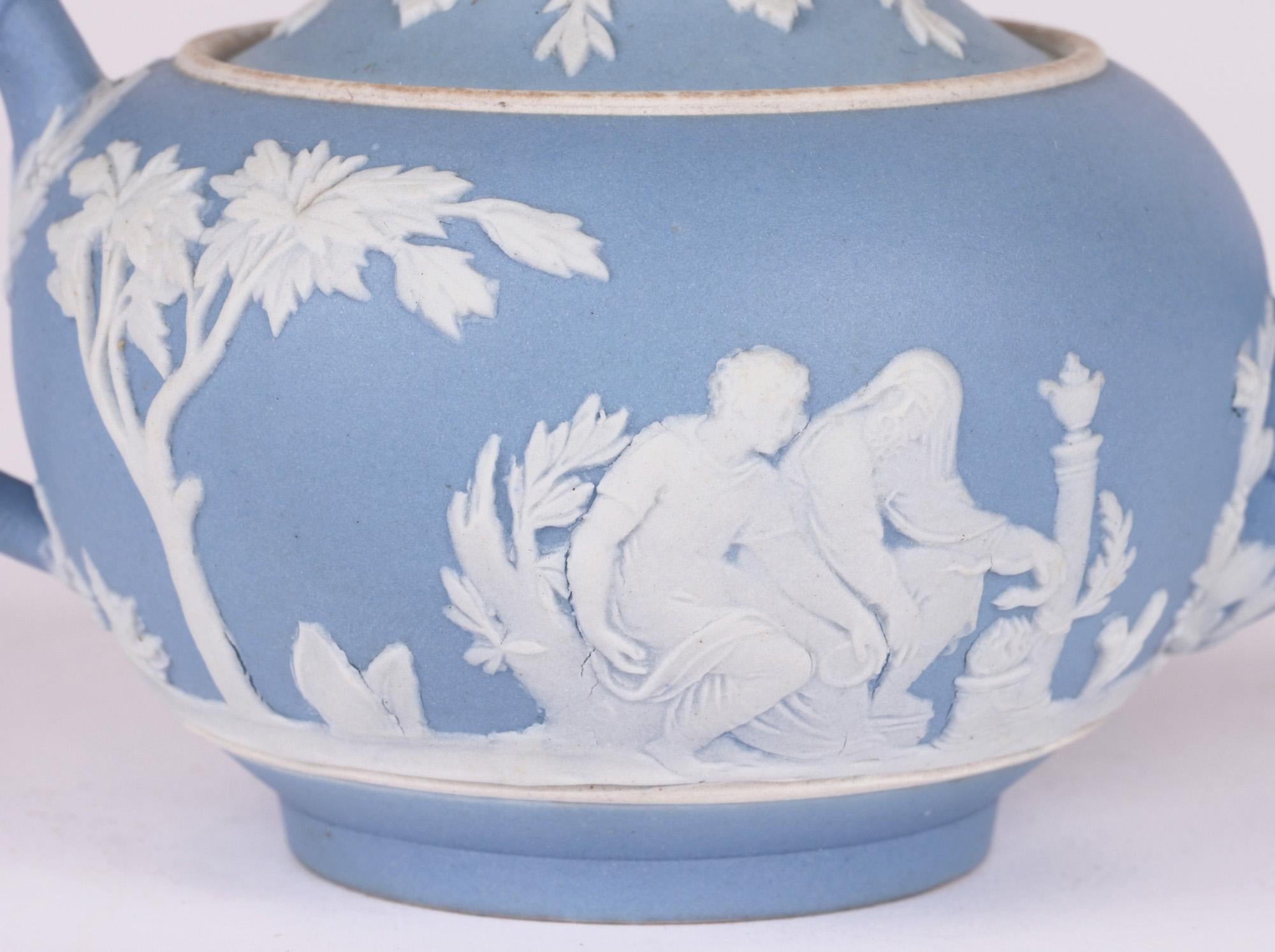 A fine antique Wedgwood blue jasperware miniature teapot decorated with classical figures and dating from the latter 19th century. The teapot of squat rounded form stands raised on a narrow round foot rim with a shaped looped handle to one side and