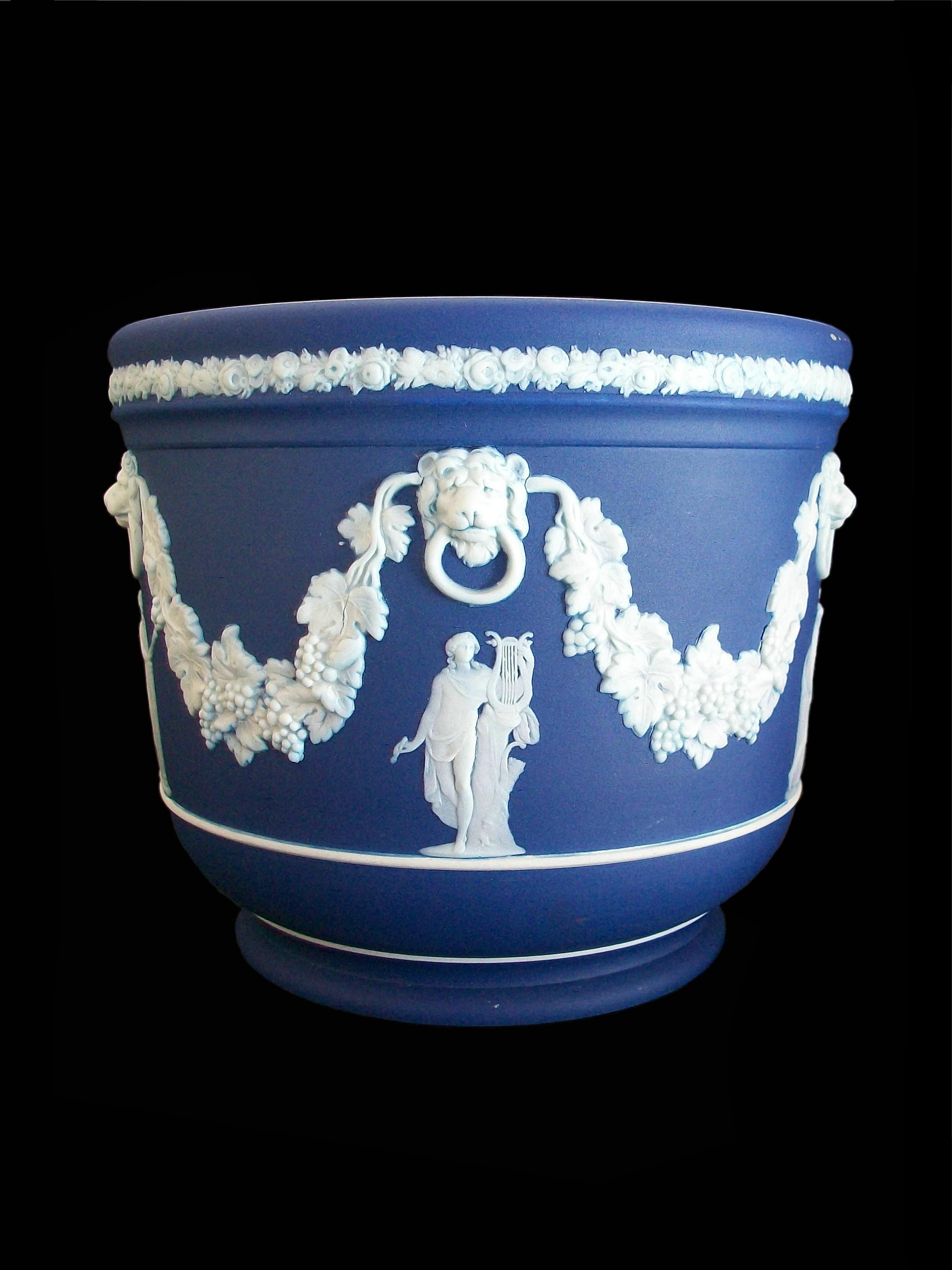 WEDGWOOD - Antique blue Jasperware Neo Classical style planter - featuring five elaborately draped classical figures beneath lions heads and garlands with grapes and leaves - finished with a band of fruits and flowers along the top edge - white