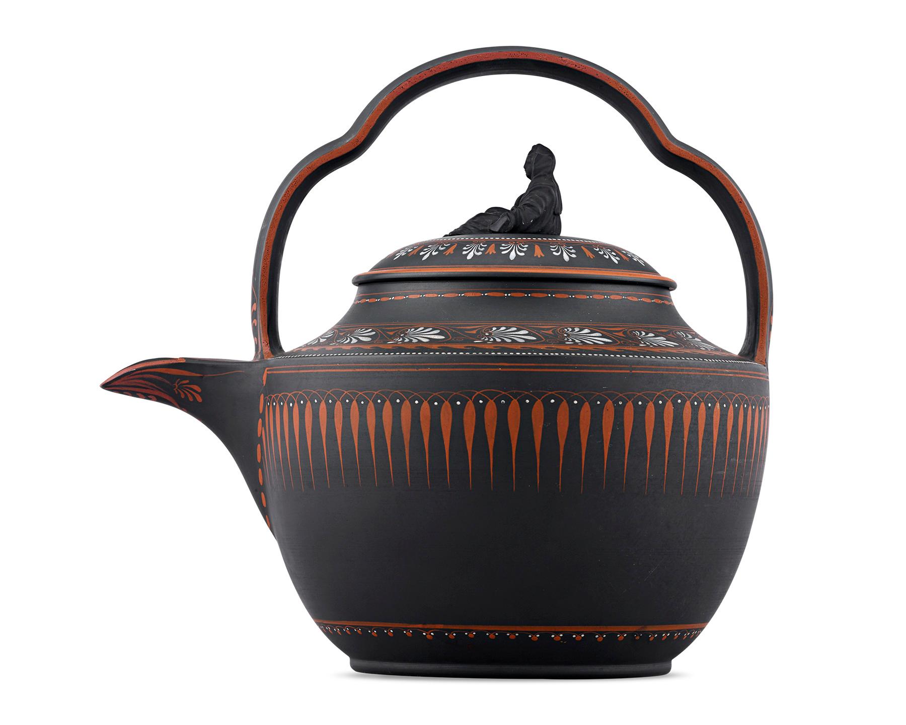 Crafted by Wedgwood, this rare, round-shaped rum kettle is comprised of black basalt and features a molded bail handle and glazed interior. Referred to as “the widow,” a “Sybil” figure of a seated woman covered head-to-toe in a shroud sits atop the