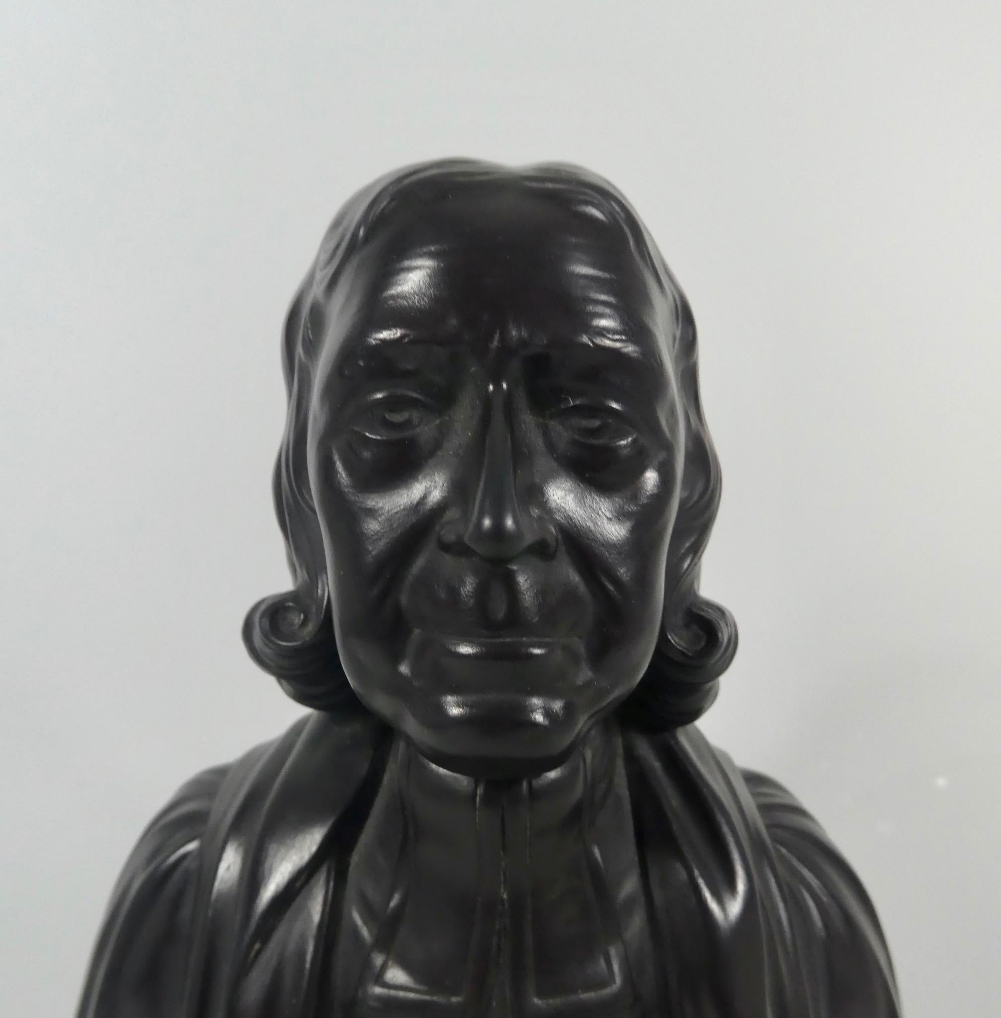 A Wedgwood Black basalt bust of John Wesley, circa 1830. Finely modelled, wearing robes, and set upon a spreading circular socle. 
Impressed ‘WESLEY’ to the reverse. 
Impressed ‘Wedgwood’ and ‘E’ to the reverse of the bust, and to the socle.