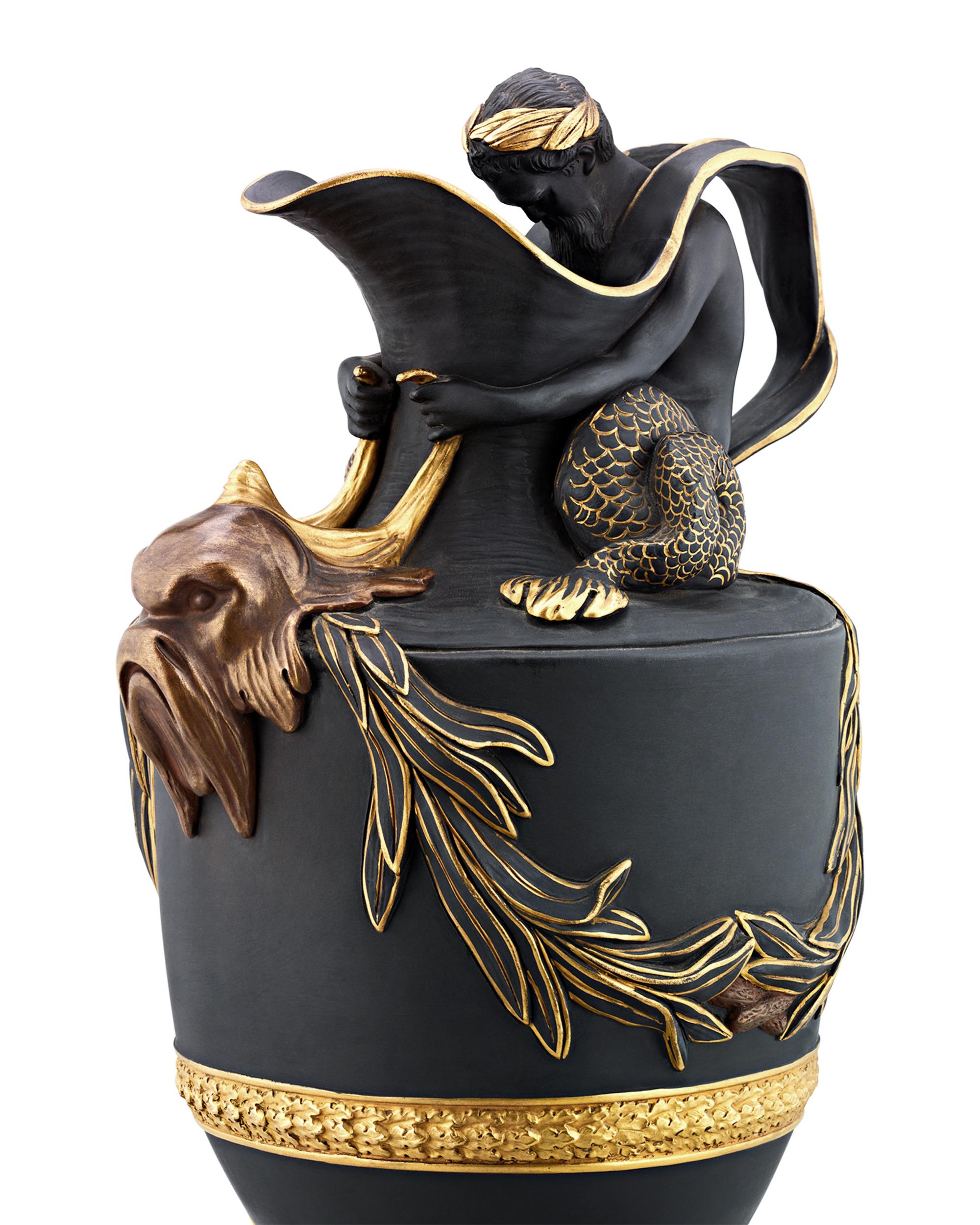 Crafted by Wedgwood, this exquisite pair of 19th-century gilt bronze and black basalt Neoclassical ewers epitomizes the quality and creativity of renowned Wedgwood designer John Flaxman. Meant to hold water or wine, each vessel showcases a