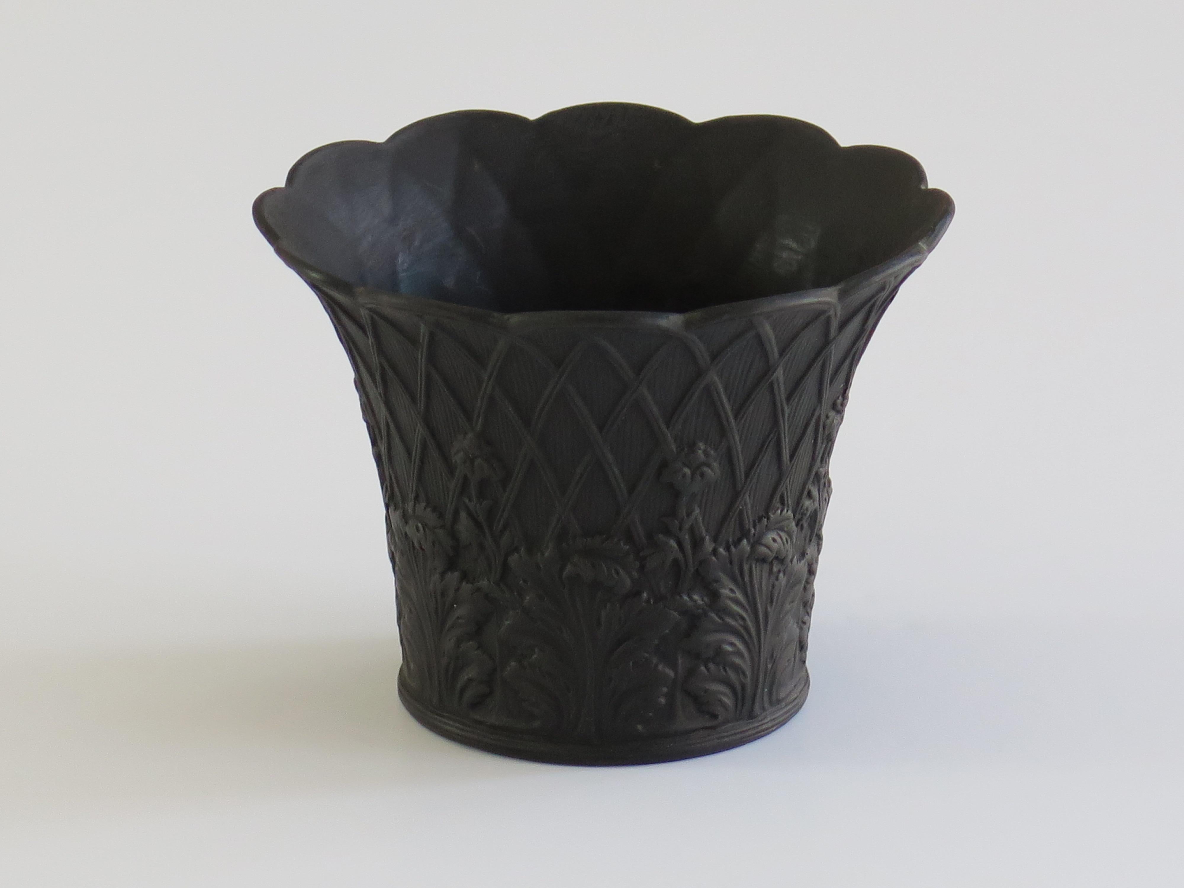 This is a good black basalt small Flowerpot, made by Wedgwood and dating to the early 20th century, circa 1920s. 

The piece is well potted in a traditional flowerpot shape with an everted rim having a wavy edge.

The decoration shows a