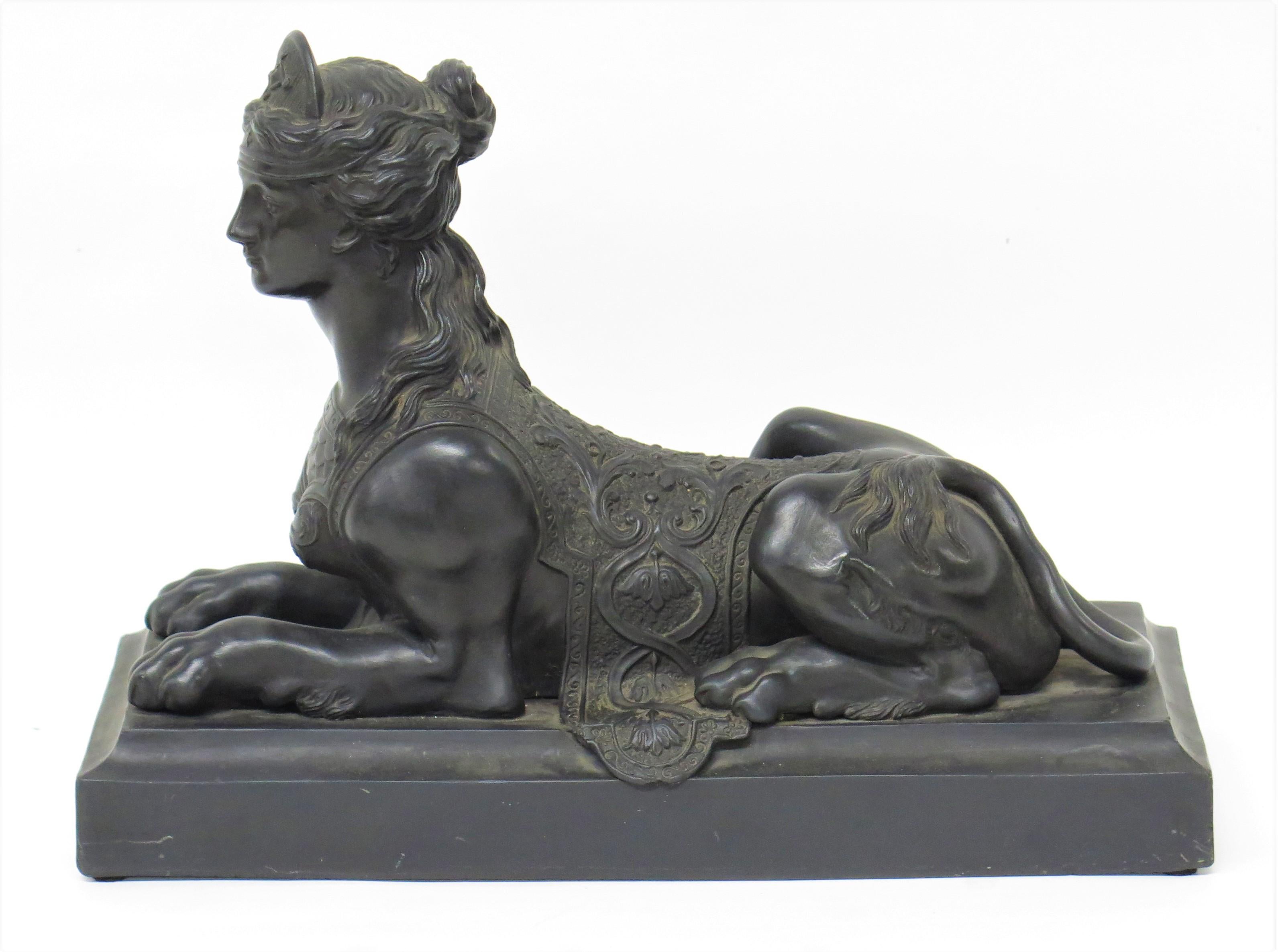a Wedgwood black basalt Grecian Sphinx after a model by sculptor John Cheere (English, 1709-1787), in the Greco-Egyptian style, depicted as a female figure with a lion's body, wearing a diadem, scaled breast plate and an elaborately patterned