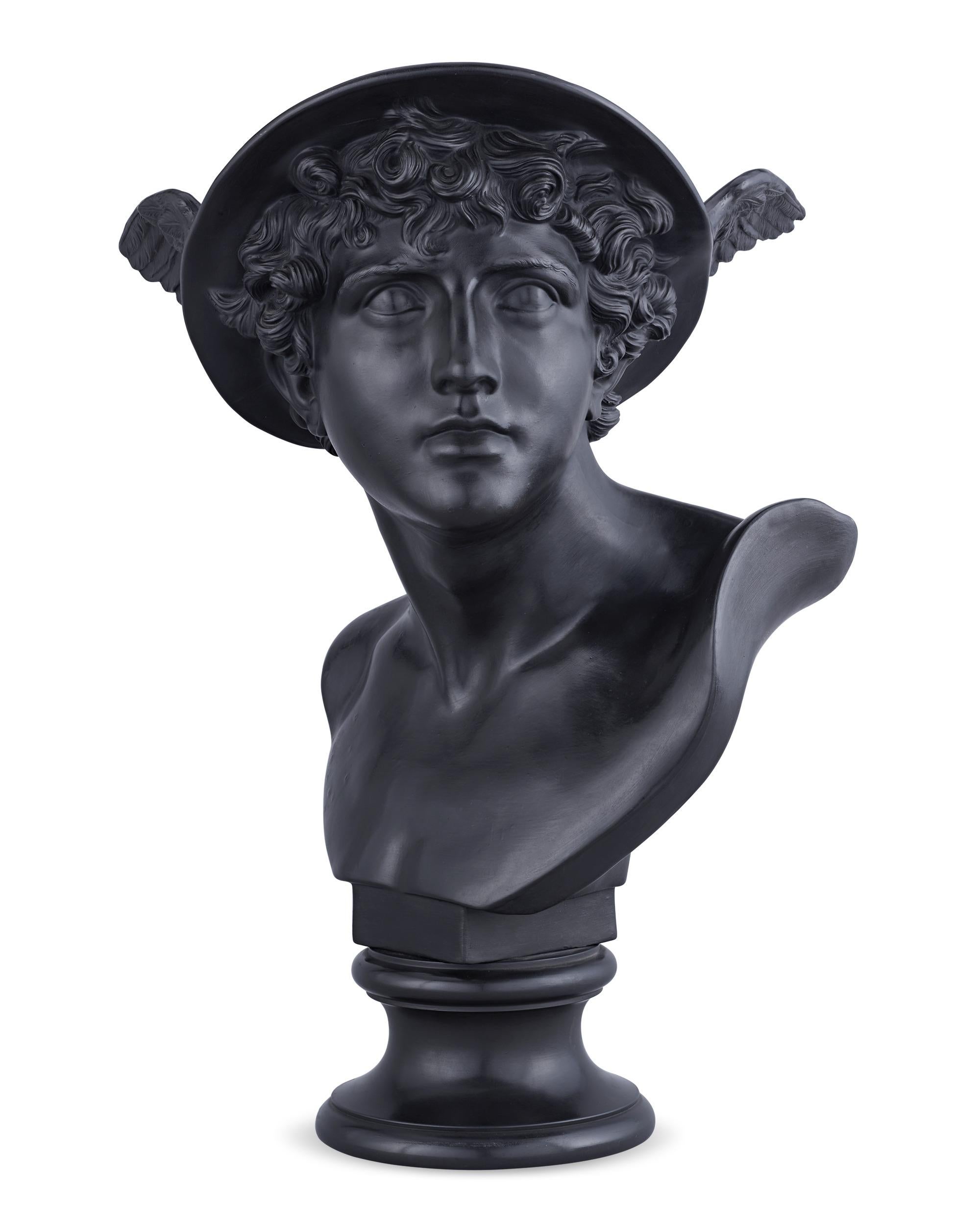 This model is attributed to John Flaxman, Jr., a celebrated English sculptor, illustrator and designer, considered a leading artist in the Neoclassical style in England. In this expertly rendered black basalt bust, Mercury, the fleet-footed Roman