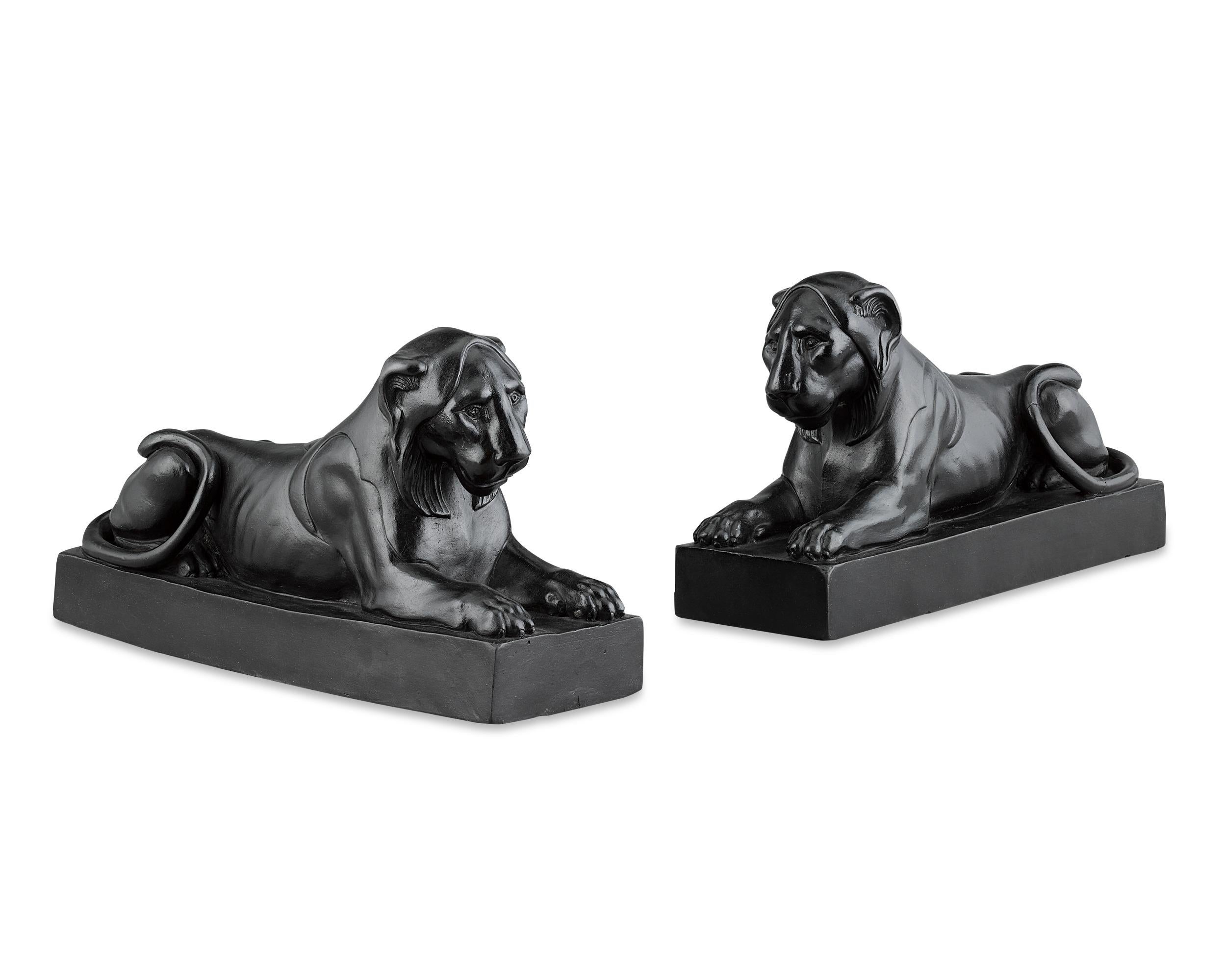 These stately and imposing lions each recline on a rectangular base, their splendidly carved faces and paws rendered in fine detail, their tails wrapped around their haunches. Caught in repose, the lions wear wise, almost pensive expressions, but