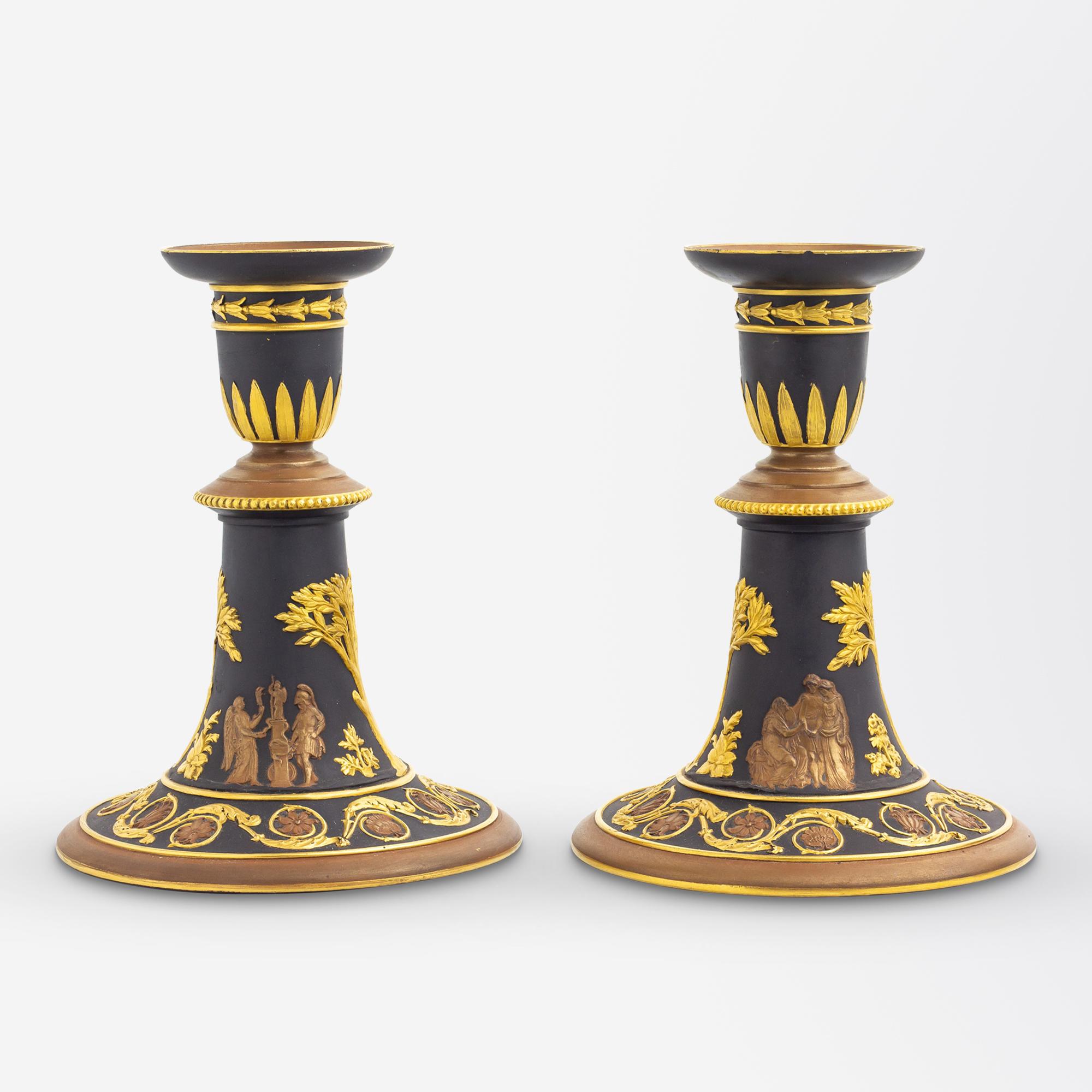 This pair of rare 19th Century candlesticks were made by Wedgwood in their famous 'black basalt'. The pair of candlesticks feature neo-classical motifs which have been parcel gilt and bronzed which is rarely seen with Wedgwood having produced very