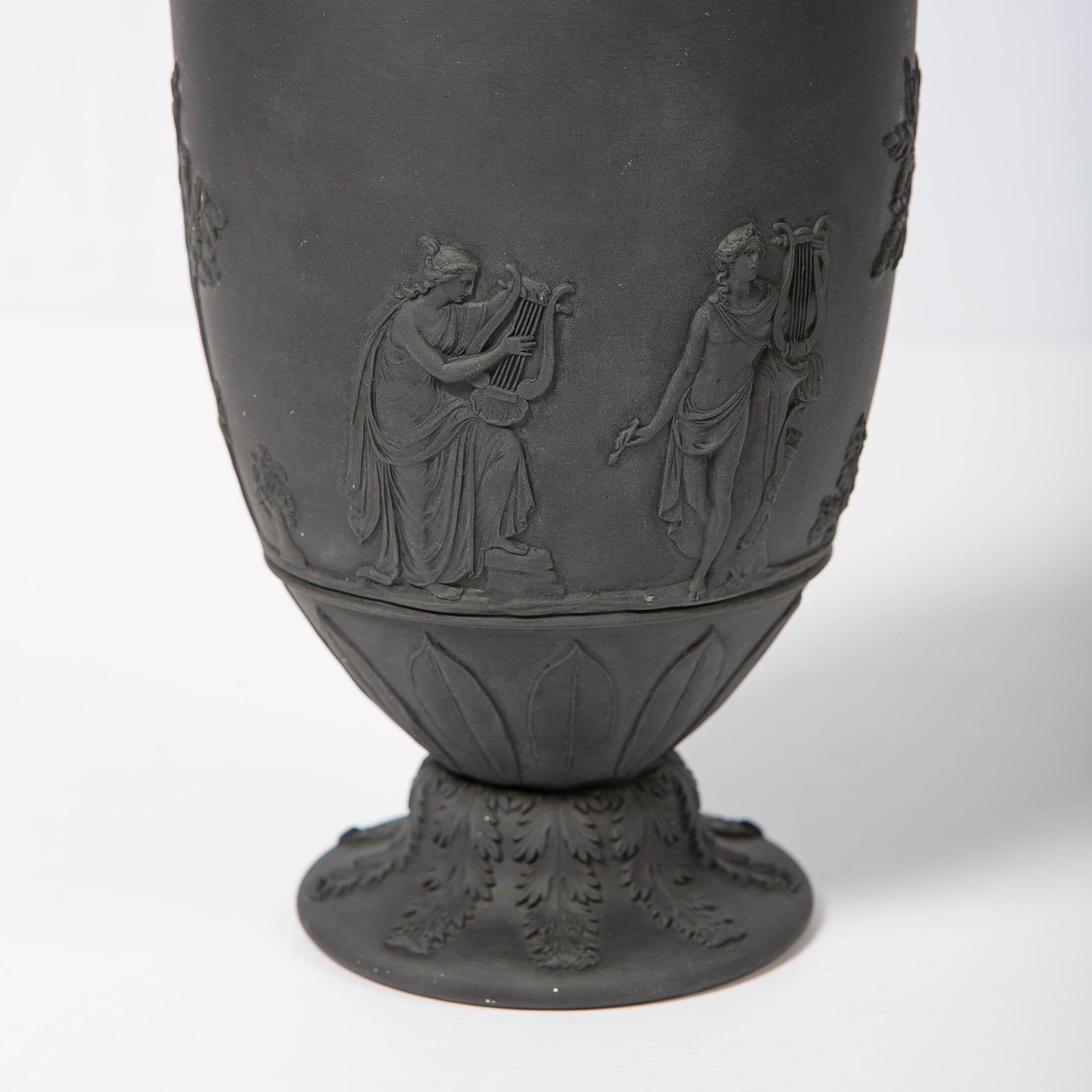 We are pleased to offer this Wedgwood black basalt vase decorated with neoclassical design. Made in England circa 1840, this double handled vase is molded in an ancient Greco-Roman shape.
It features classical figures with musical instruments, and