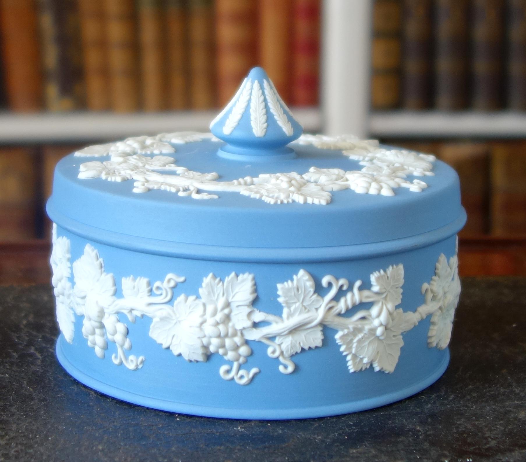 Large Wedgwood jasperware lidded candy box, beautiful neoclassical style item decorated with antique-style white grapes friezes on a sky-blue background.
Second half of 20th century refined and highly decorative item that reminds 18th century
