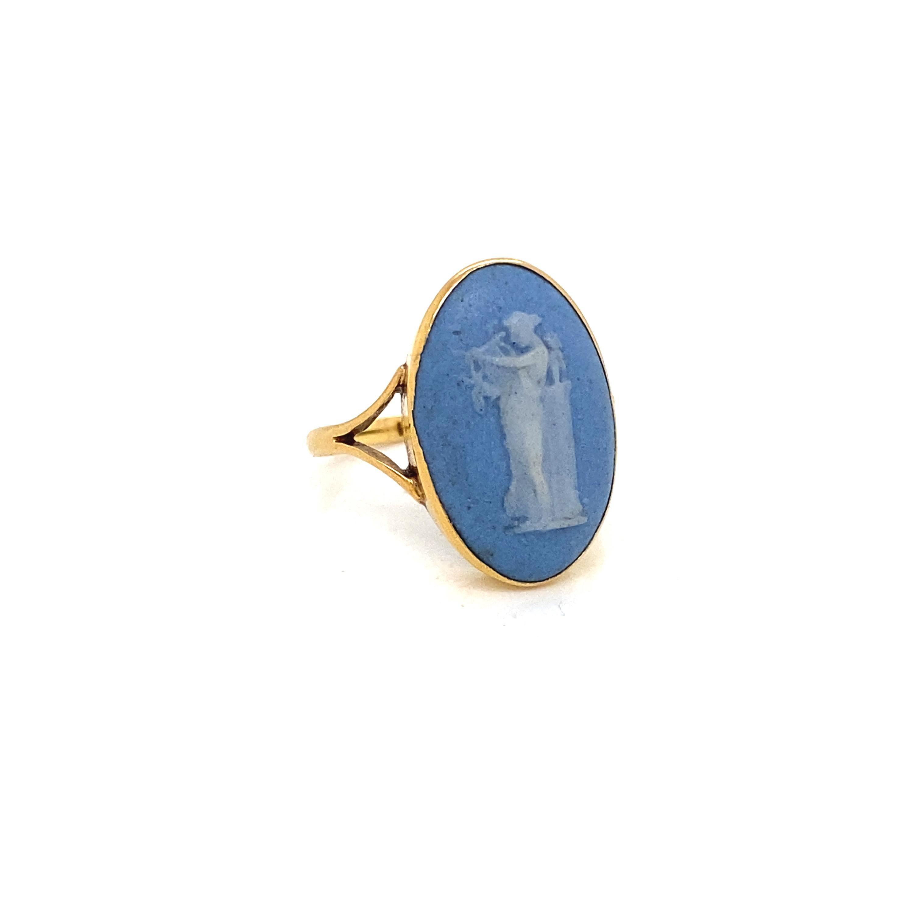 Voici une merveilleuse bague vintage de Wedgwood, fabricant anglais de porcelaine, de porcelaine fine et d'accessoires de luxe.

La bague est centrée sur un camée bleu pastel et blanc de 16,8 x 10,9 mm représentant une femme jouant de la harpe,