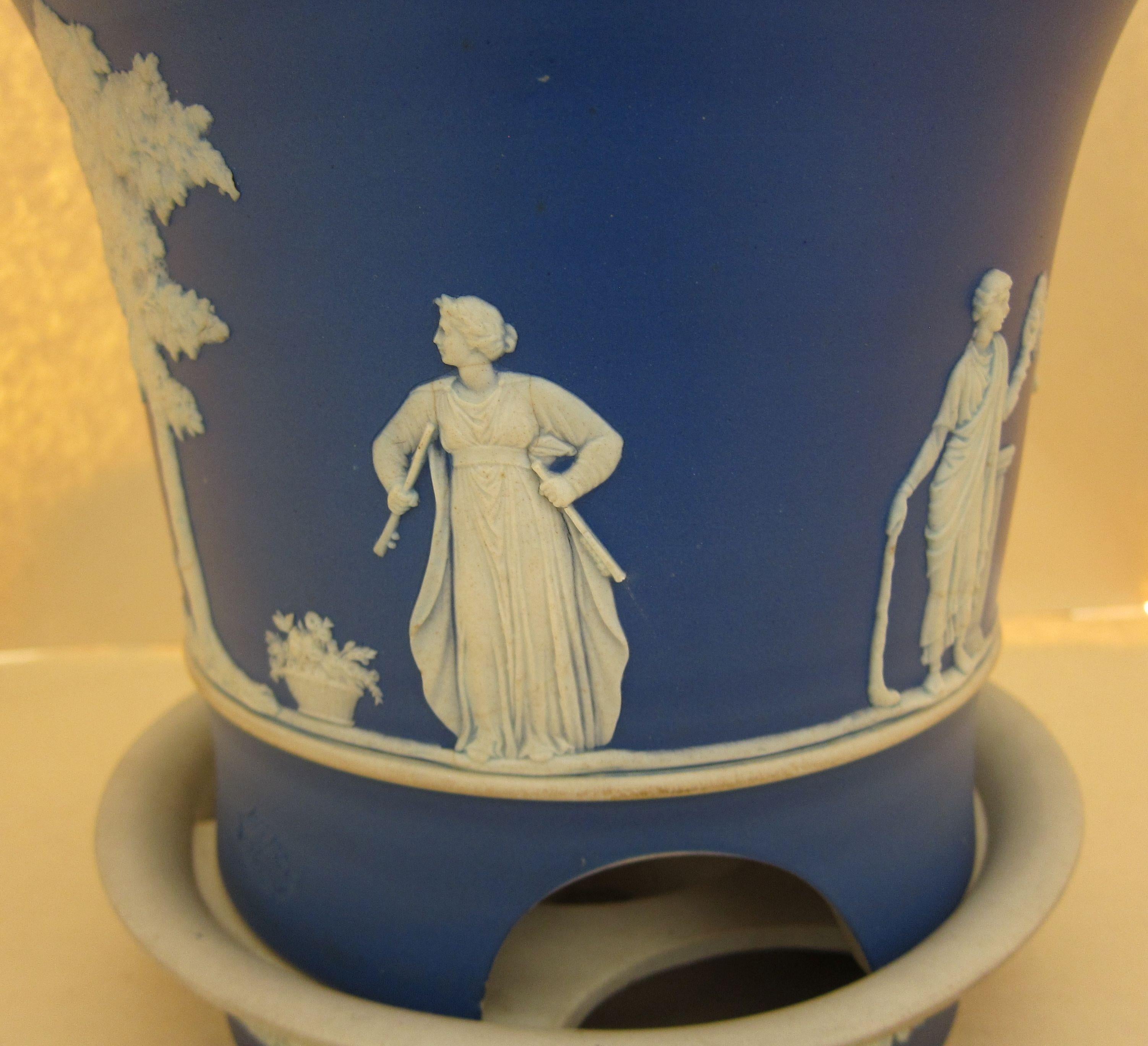 A Wedgwood blue Jasperware jardinière and stand in a rare form with impressed Wedgwood marks and registration marks with white applied decoration.
