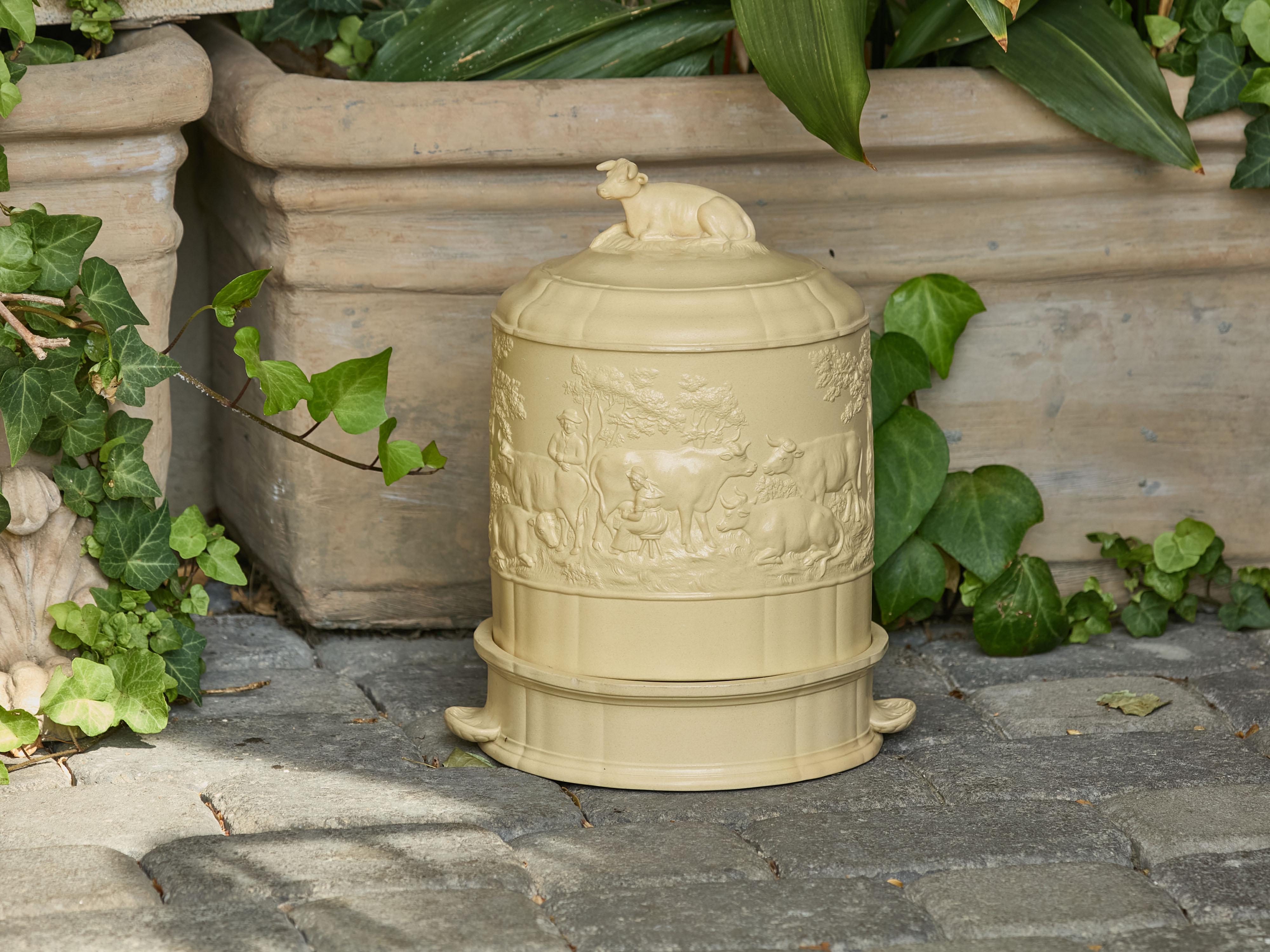 Un plat à fromage en faïence de Wedgwood et son couvercle bombé, datant d'environ 1850, avec une vache et des activités laitières en bas-relief. Attirant notre attention par ses détails délicats, ce dôme à fromage de Wedgwood Caneware, datant