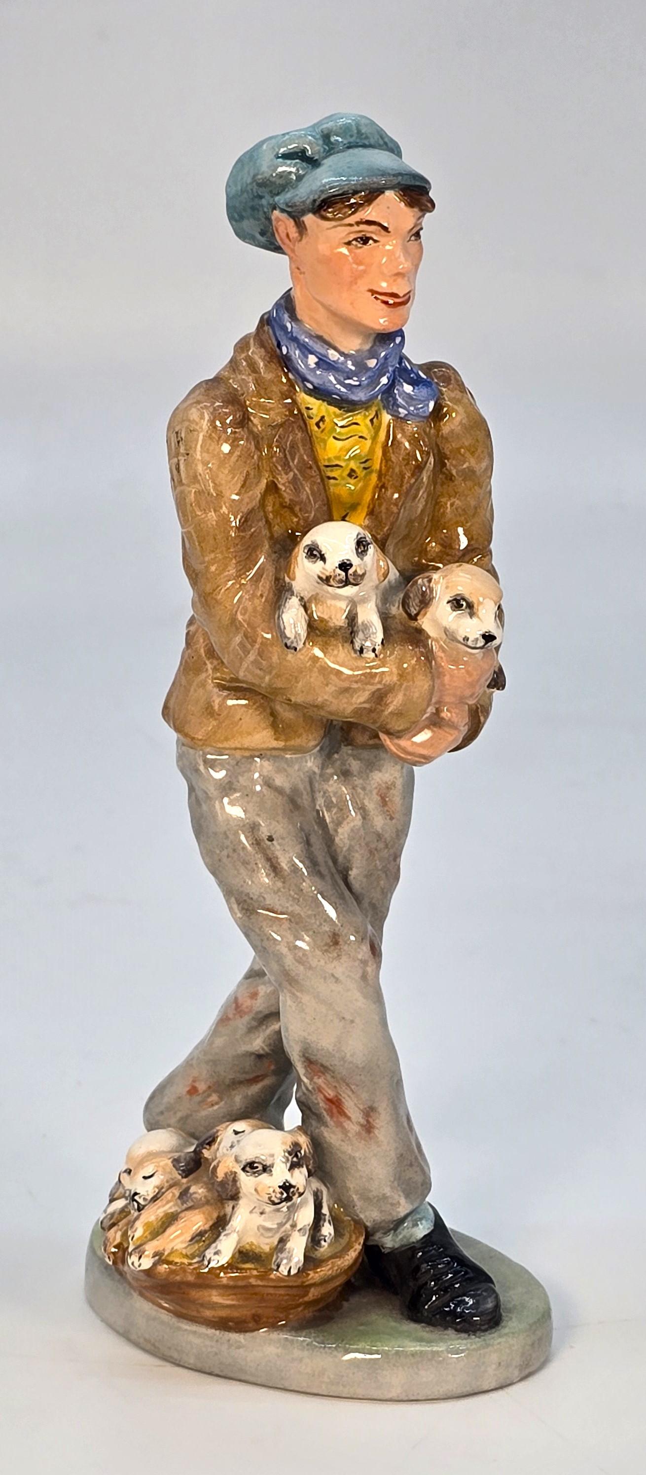 Uno scarso Wedgwood & Co. di epoca edoardiana. Ltd, Inghilterra, deliziosa figura in Cina dipinta a mano del venditore di cuccioli.

Una figura maschile rurale con un viso caratteristico, vestita con una giacca di tweed di campagna, una camicia
