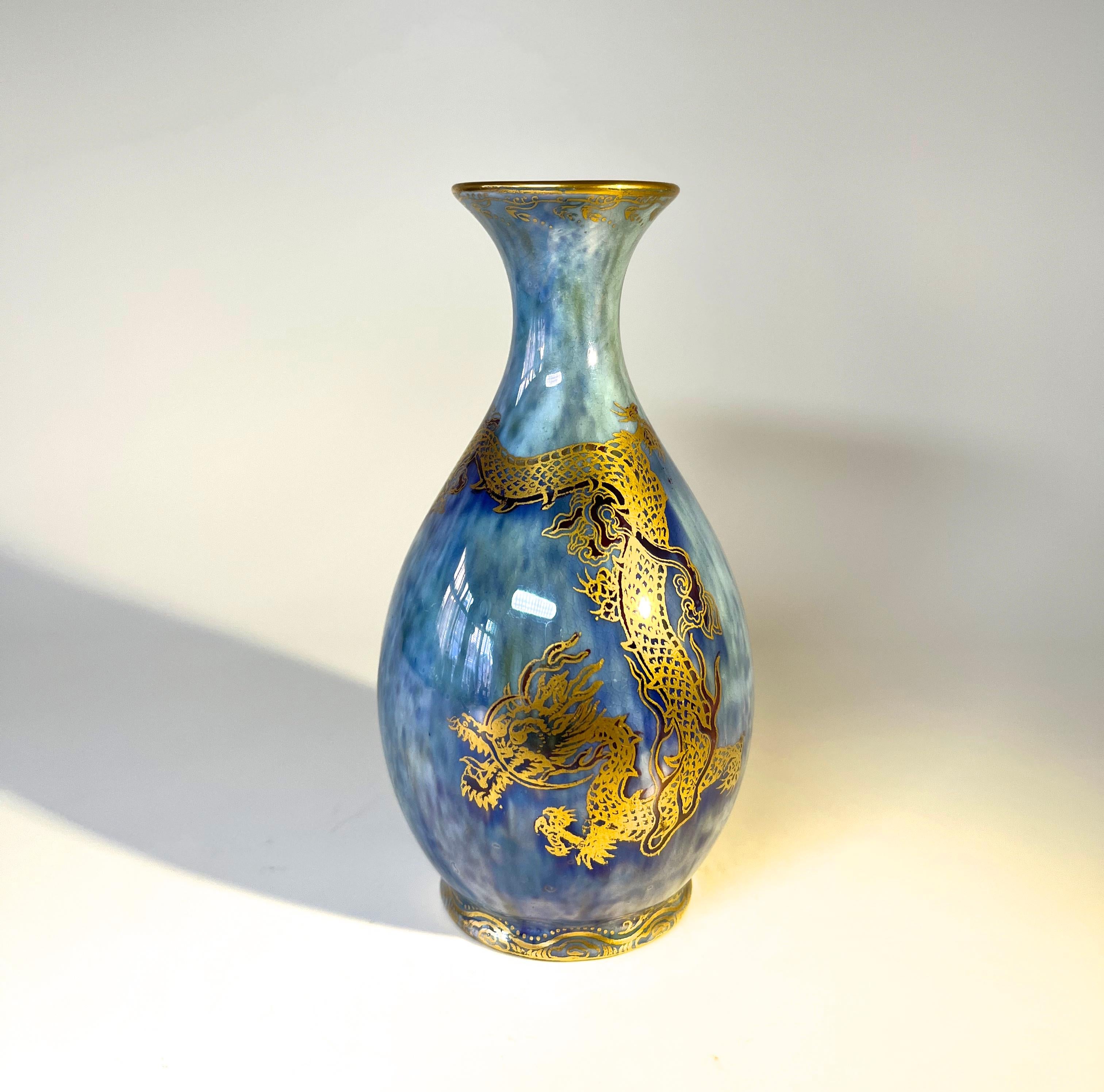Superb Wedgwood Ordinary lustre bud vase by Daisy Makes-Jones.
Dominated by a dramatic gilded crested dragon on a mottled cerulean blue background. 
Gilded filigree surround both upper and lower rims
The interior is a delicate cream pearl lustre