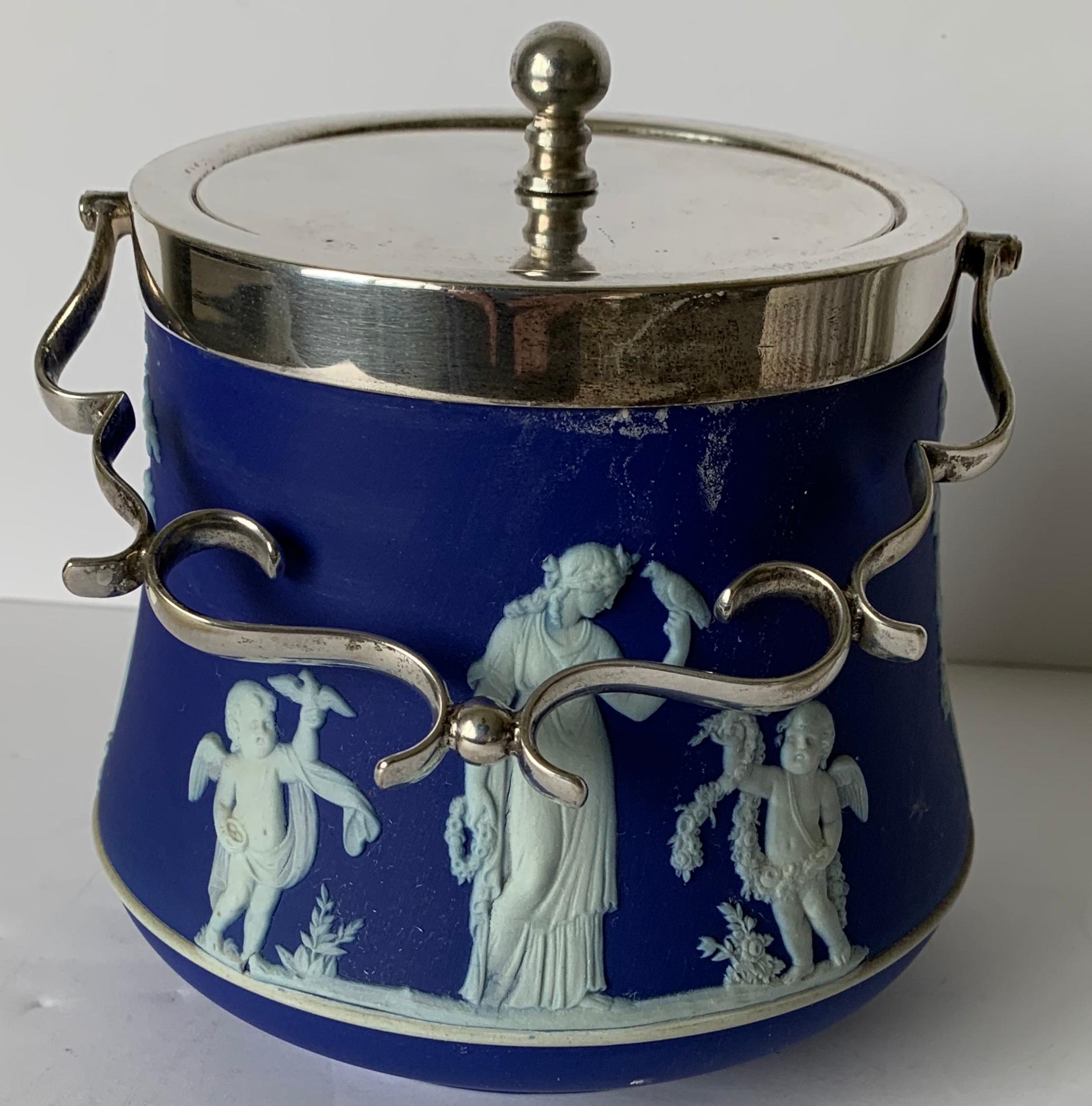 Wedgwood dark blue bell shaped jasperware biscuit barrel overall neoclassical motif with a silver plated lid and handle. Stamped Wedgwood on the underside and lid is marked.