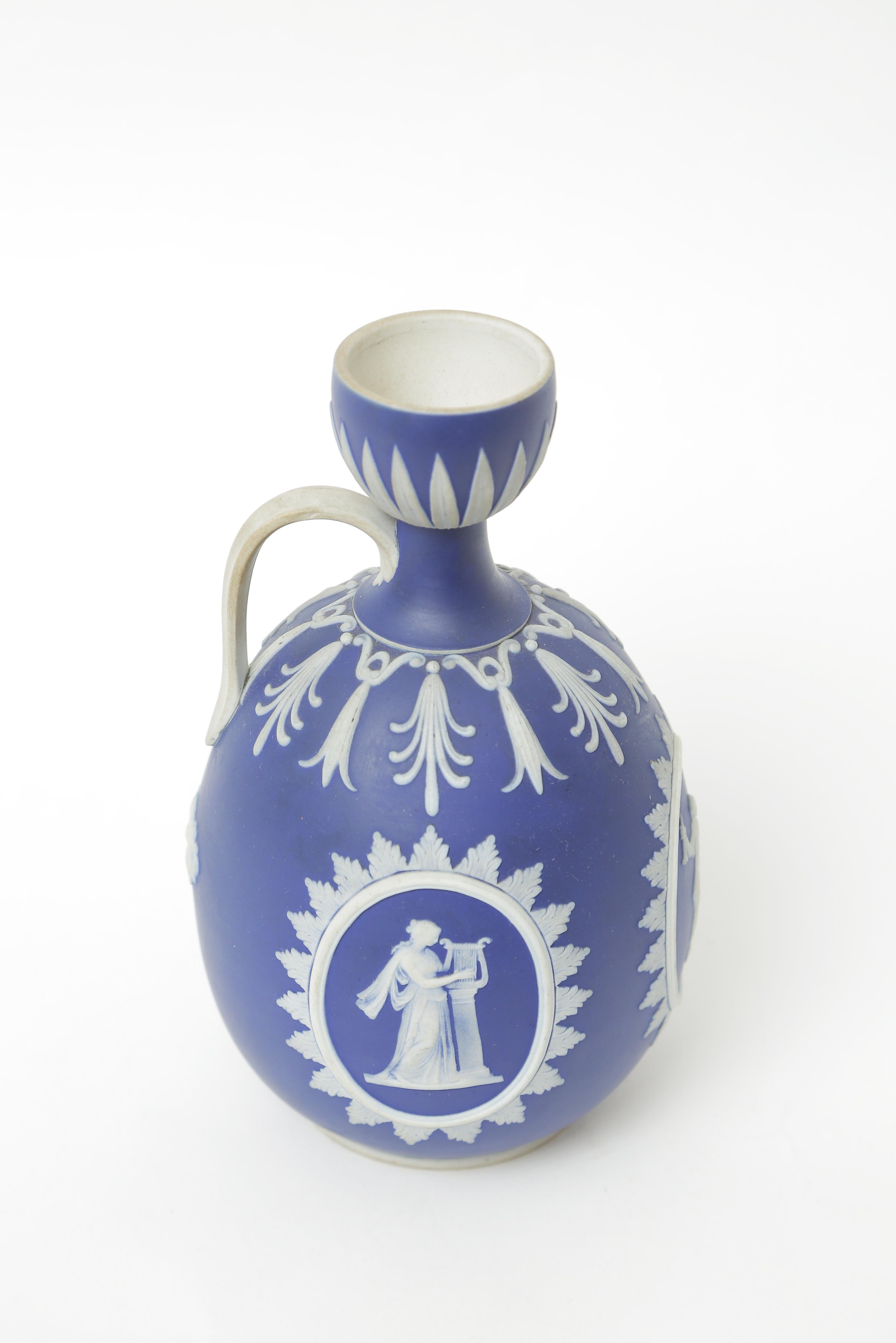 A Classic and elegant Wedgwood England piece with fine white jasperware relief on their dark blue or cobalt ground. This piece also features a single handle and nice shaped body.