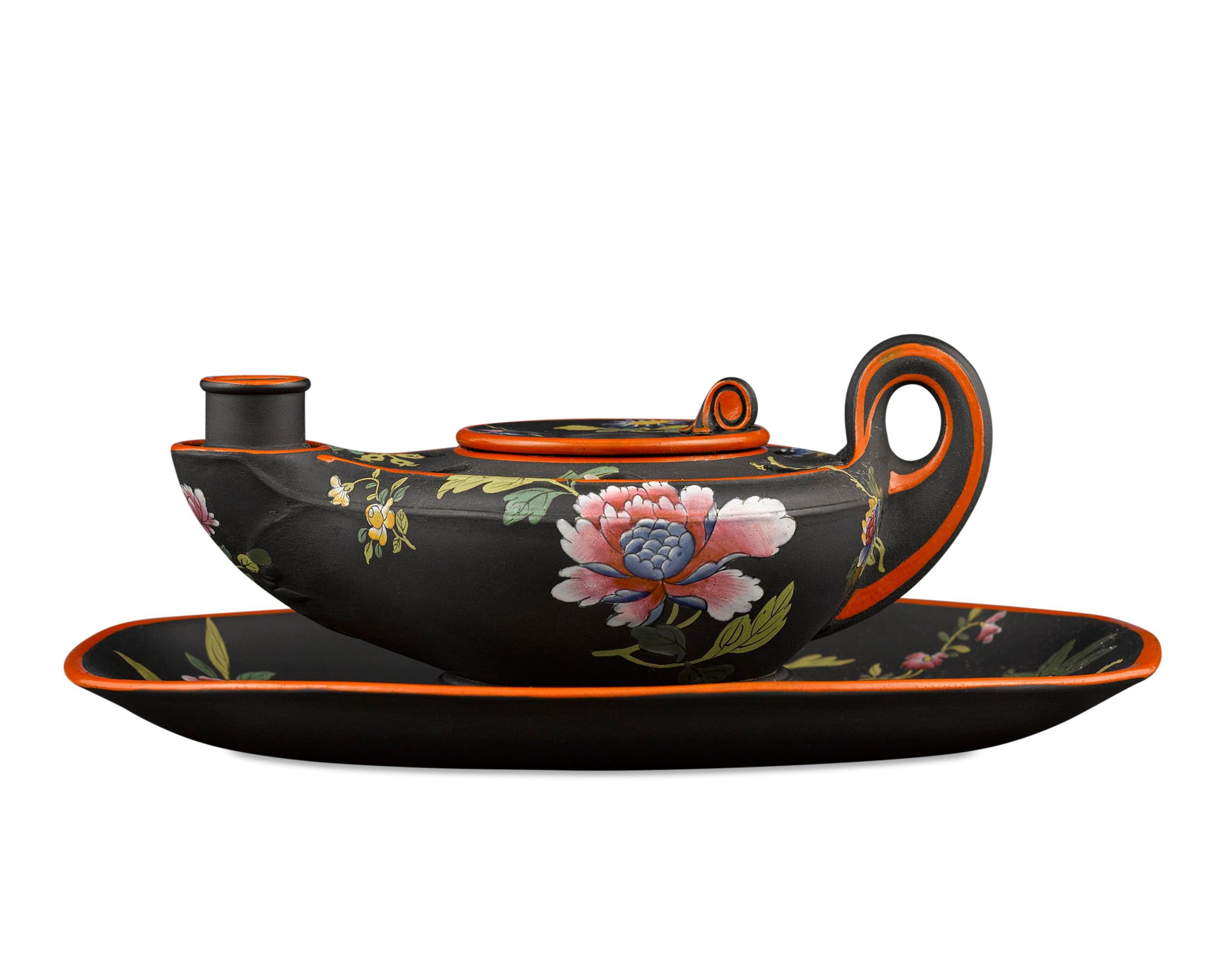 This enchanting antique Wedgwood black basalt inkwell is crafted in the form of an ancient oil lamp. With a removable well and holes for storing pens and quills, it is decorated with exquisitely hand painted enamel in a Chinese-inspired floral