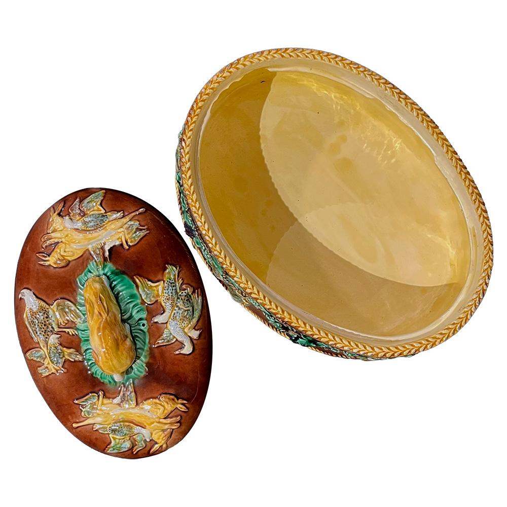 Introducing this stunning 19th-century Wedgwood terrine, a timeless piece of elegance. Crafted in earthenware with captivating hues of ochre, blue, brown, and green, this oval terrine draws the eye. Adorned with delicate vine motifs and relief