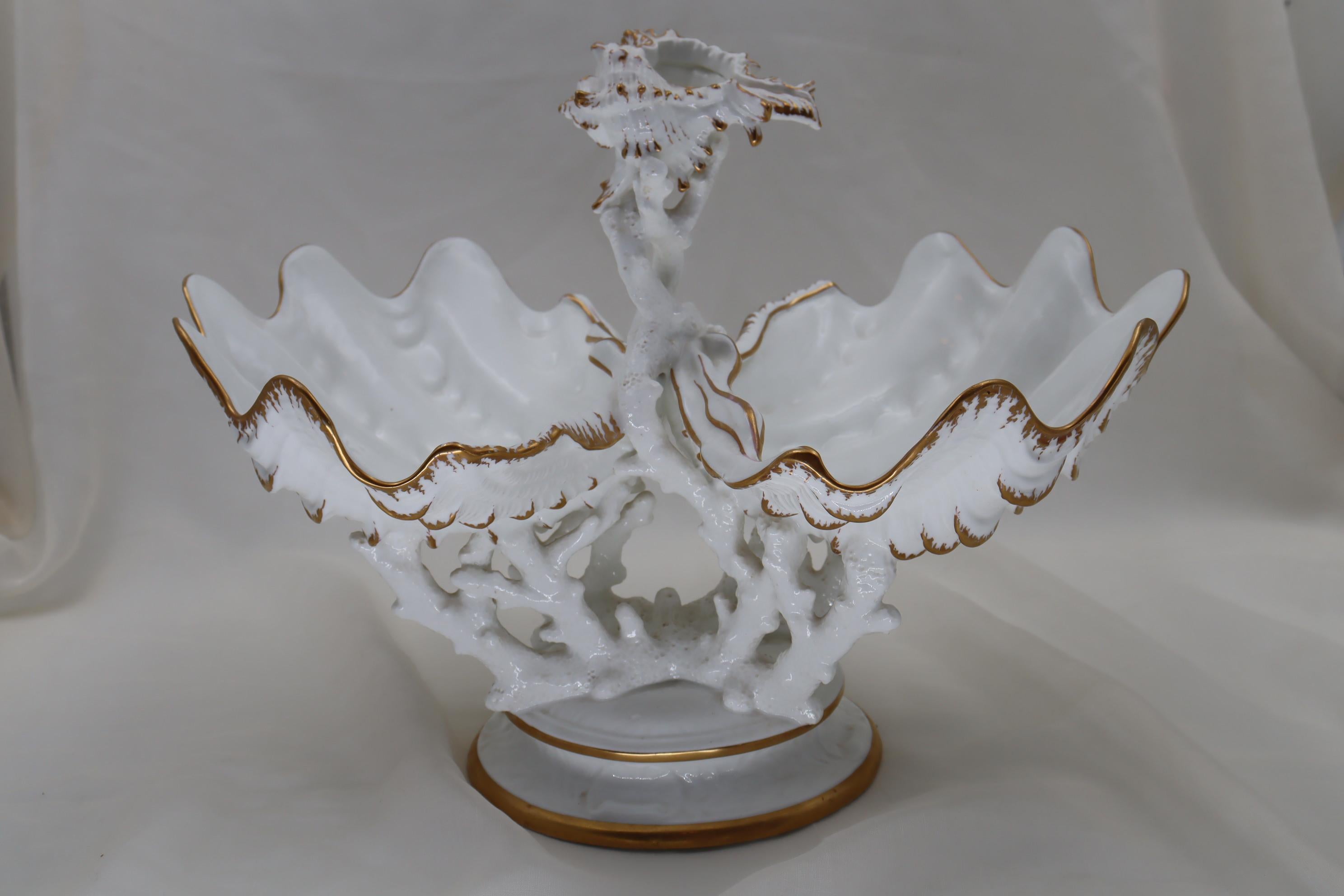 This eyecatching Wedgwood gilt bone china centrepiece is formed by two half clam shells supported on antler coral, which then rests on a round base. Rising up between the shells is more coral, on top of which sits a murex shell. The only decoration
