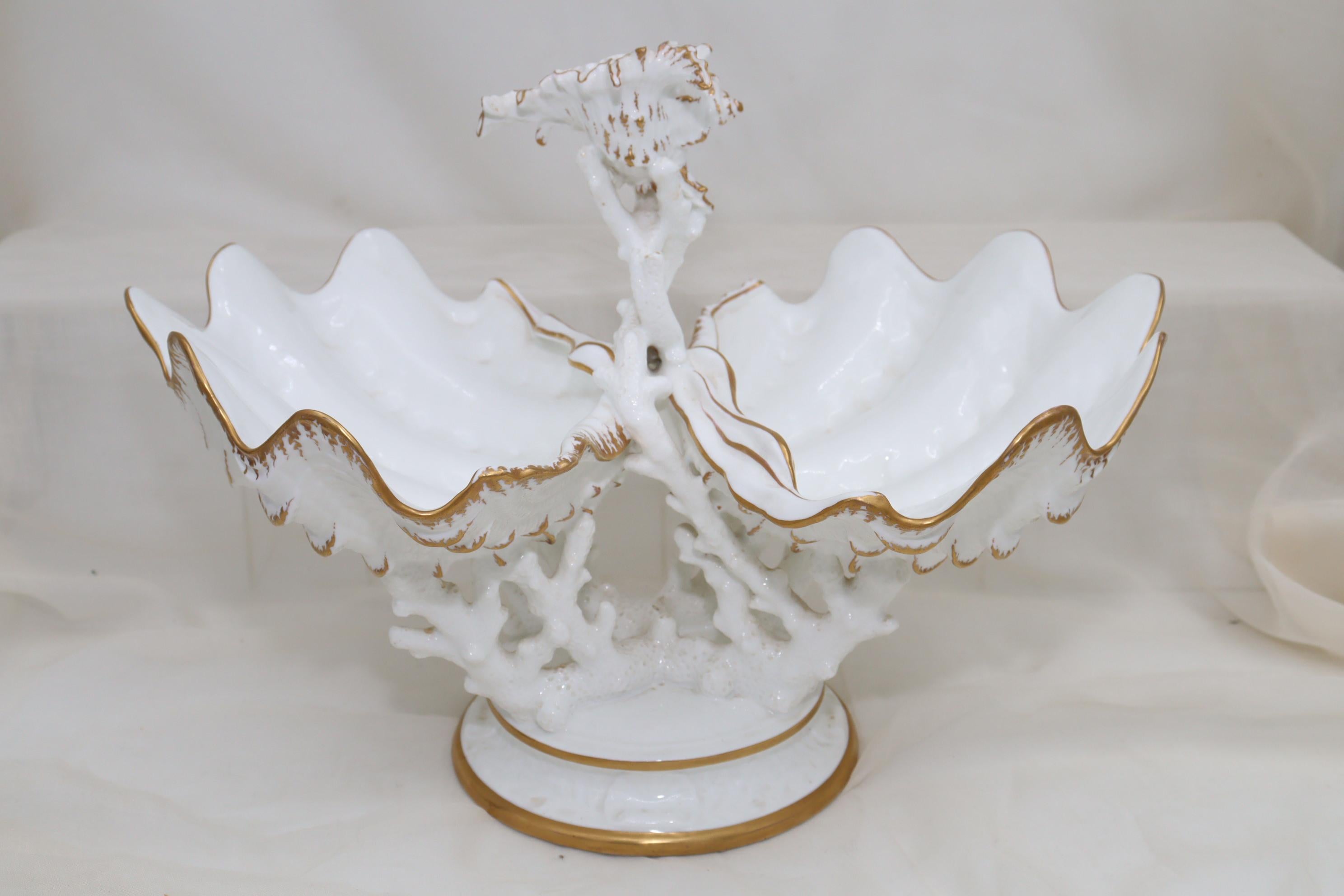 This eyecatching Wedgwood gilt bone china centrepiece is formed by two half clam shells supported on antler coral, which then rests on a round base. Rising up between the shells is more coral, on top of which sits a murex shell. The only decoration