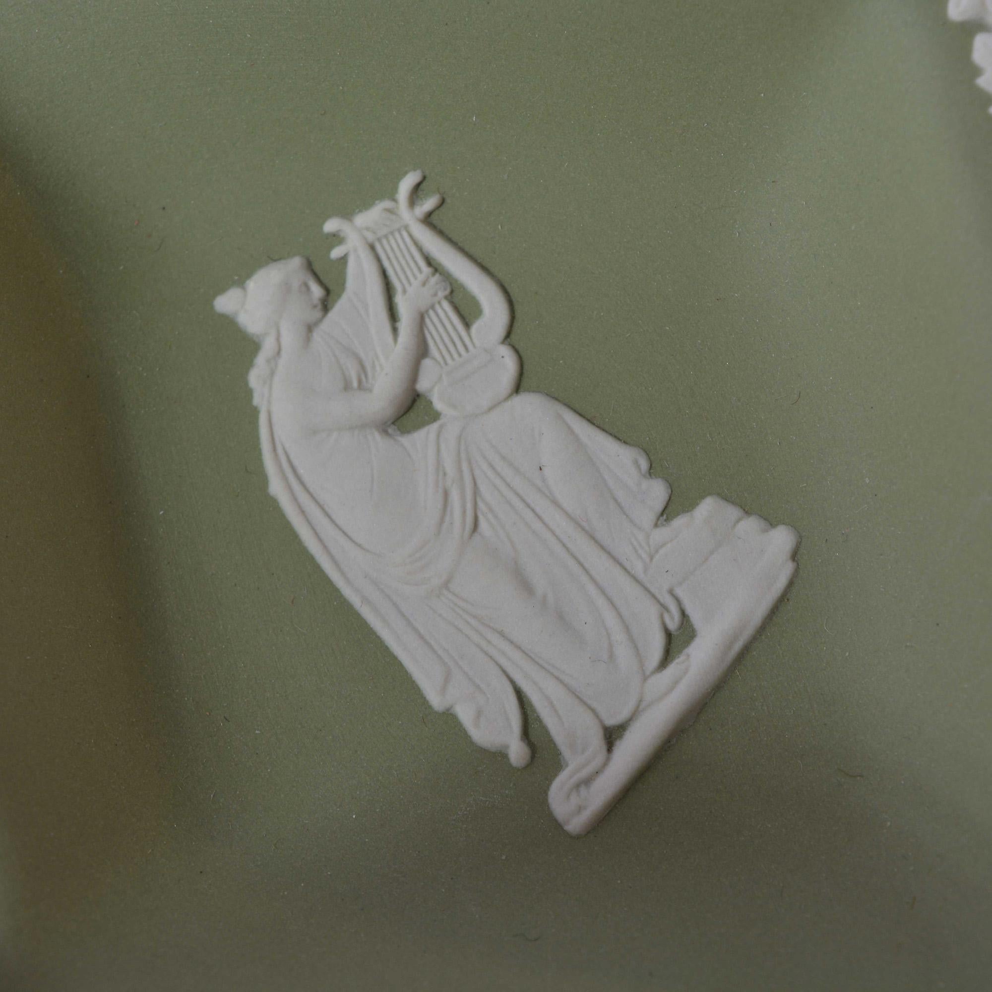 This Wedgwood tray has a green base with the signature ivory relief pattern featuring a Grecian goddess with a harp. Marked on the back.