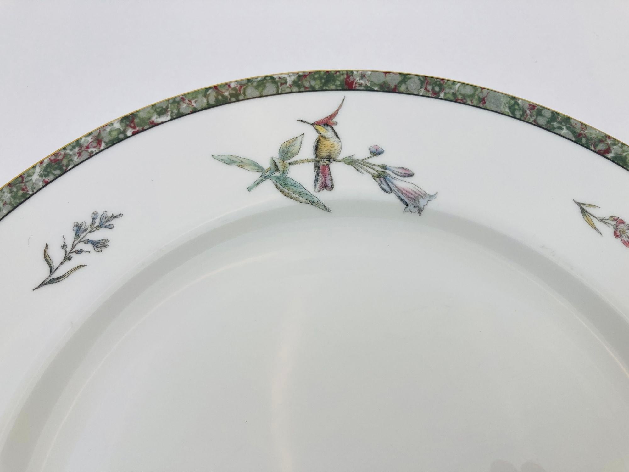 Fine Bone China plate with marbled trim decorated with hummingbirds and gold trim.
This Humming Birds pattern was manufactured for 11 years by the Wedgwood China company.
Beautiful humming birds play around the pattern, accented by a marbled