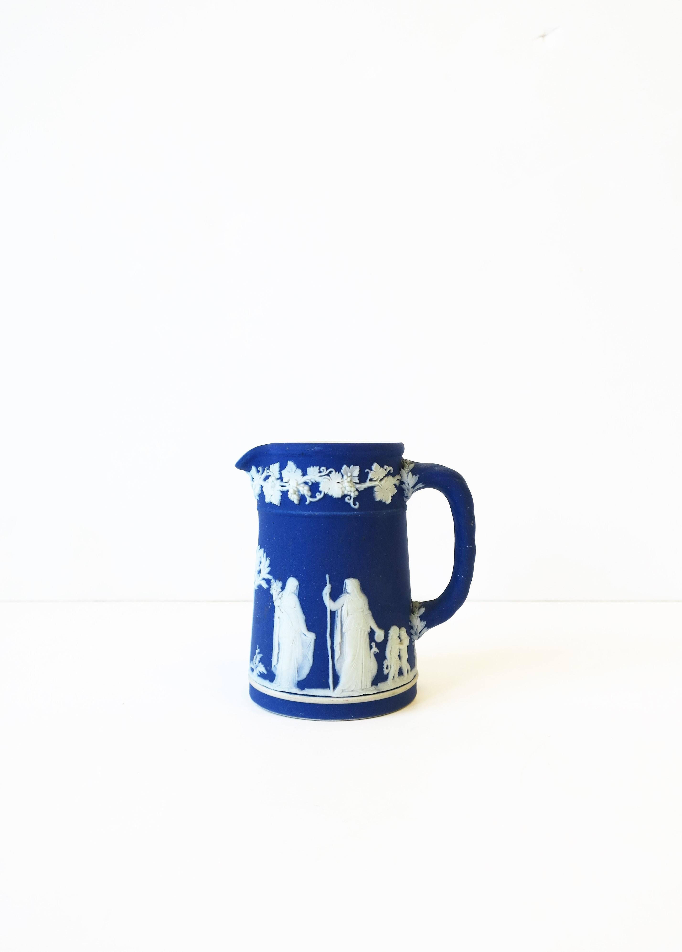 An antique neoclassical Wedgwood Jasperware cobalt blue and white pitcher, made in England, circa late 19th century. Pitcher has a beautiful detailed raised relief on matte unglazed stoneware. With maker's mark on bottom as shown in images: Marks