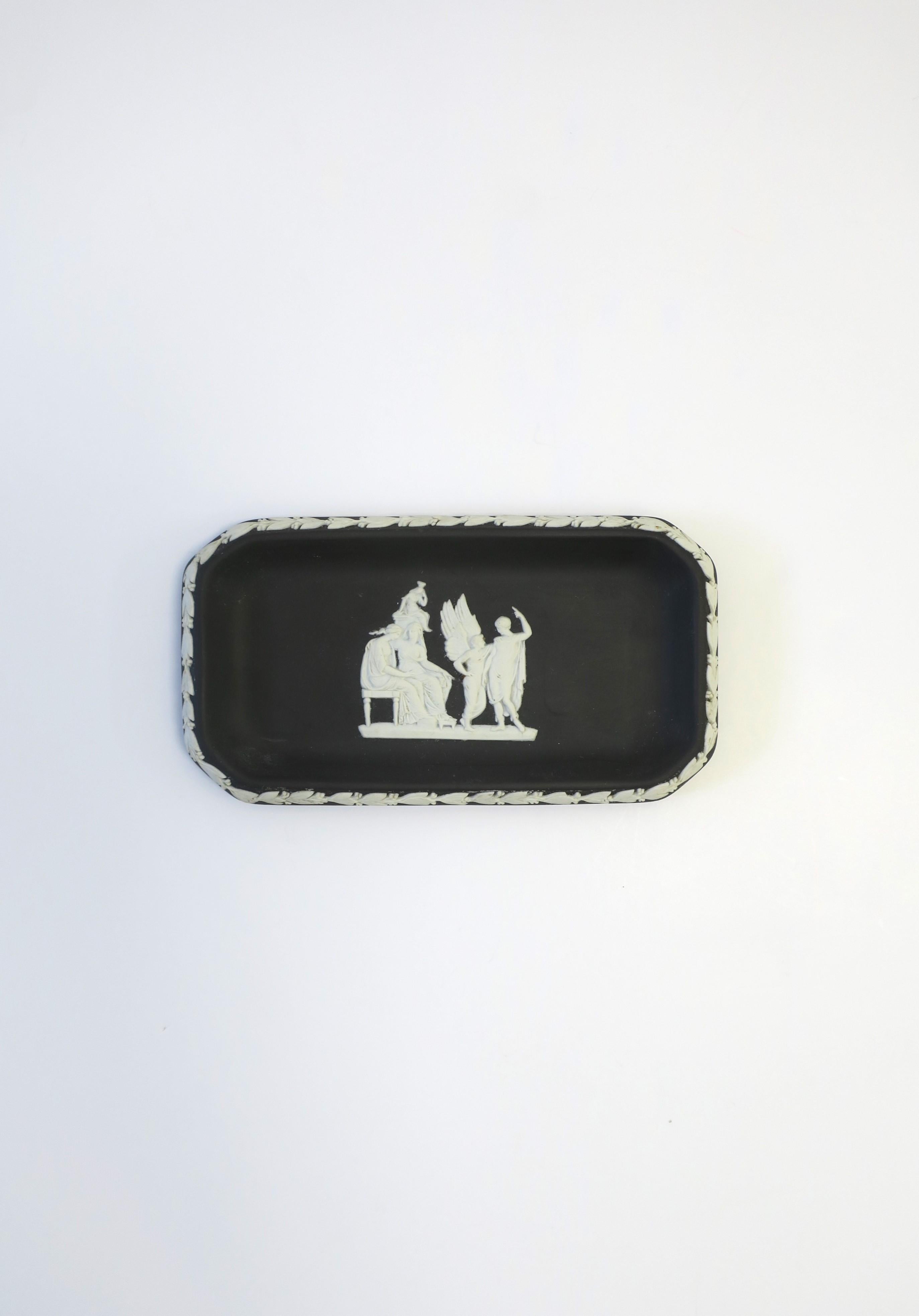 An English Wedgwood Jasperware black basalt and white stoneware rectangular jewelry dish with Neoclassical design, 1963, England. Piece is a matte black basalt stoneware with a white Neoclassical raised relief center and leaf design around edge.