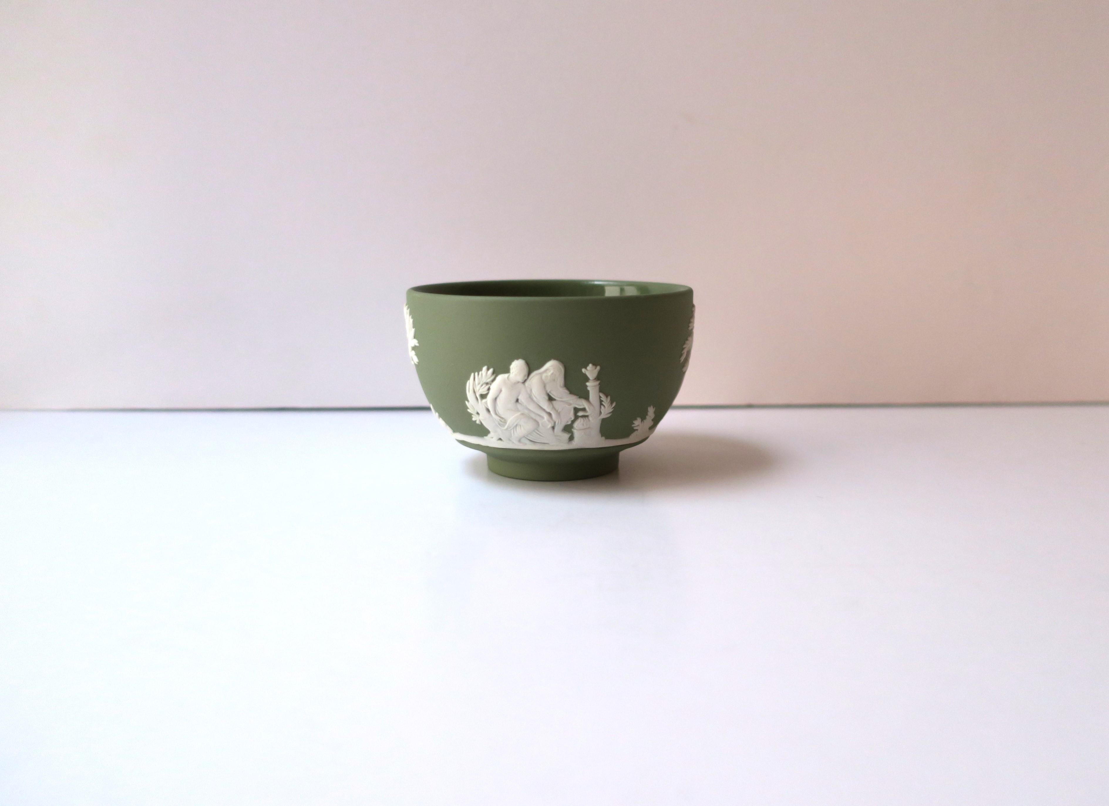 An English sage green and white Jasperware matte stoneware small footed bowl by Wedgwood, in the Neoclassical style, circa mid-20th century, 1960, England. A small, footed bowl, in a matte stoneware with raised relief scenes around exterior, in the