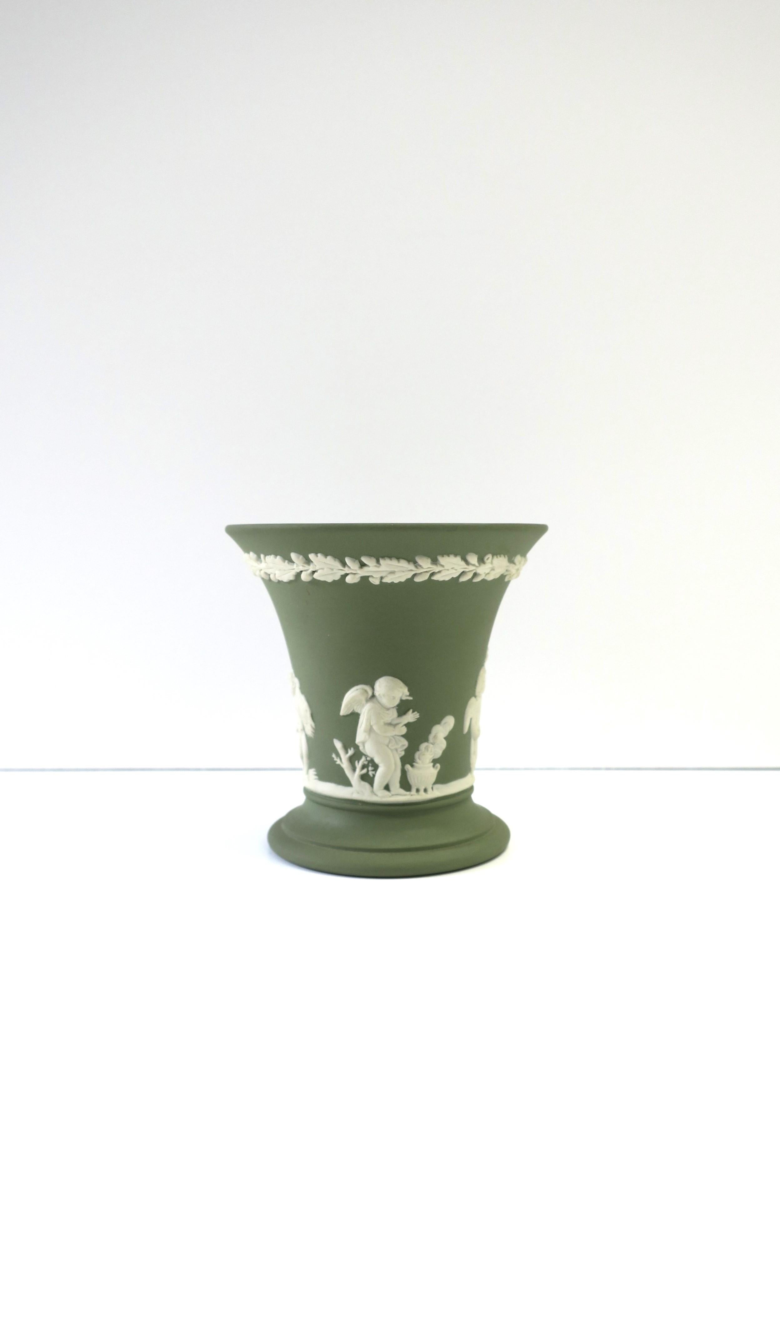 A beautiful 'sage' green and white English Wedgwood Jasperware matte stoneware vase in the Neoclassical style, England, 1973. Vase has Renaissance/Neoclassical raised white relief scene around exterior. All authentication markings on bottom
