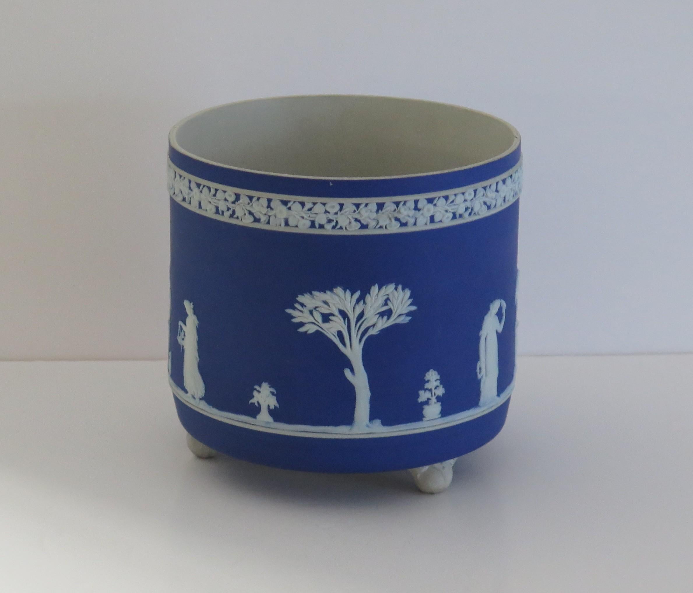 Si tratta di un ottimo jardiniere o cache pot in gres Jasperware, prodotto da Wedgwood, Inghilterra, risalente agli anni '30 circa. 

La jardiniere ha una forma deliziosa, molto simile a quella di un vaso a spazzola ed è ben incastonata su tre
