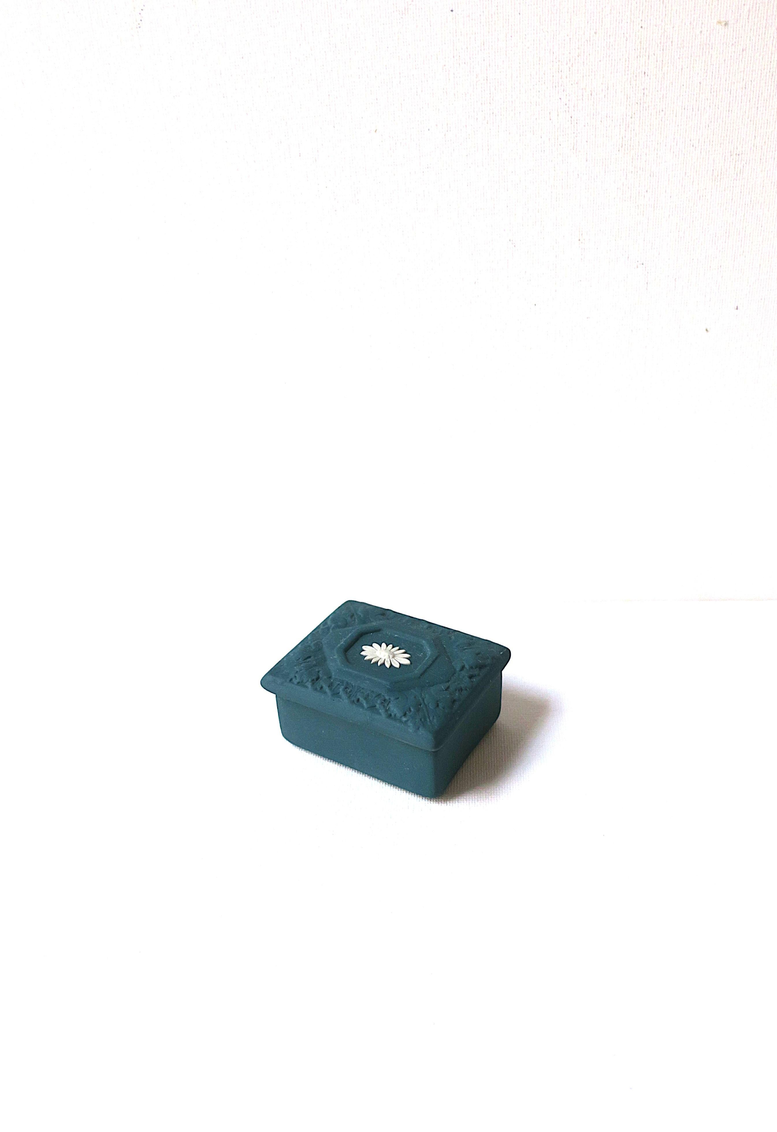 A small English Wedgwood Jasperware jewelry or trinket box with flower design, circa late-20th century, England. Box is a beautiful matte stoneware in a dark teal green with a stone-white flower on top lid. A great piece to hold jewelry