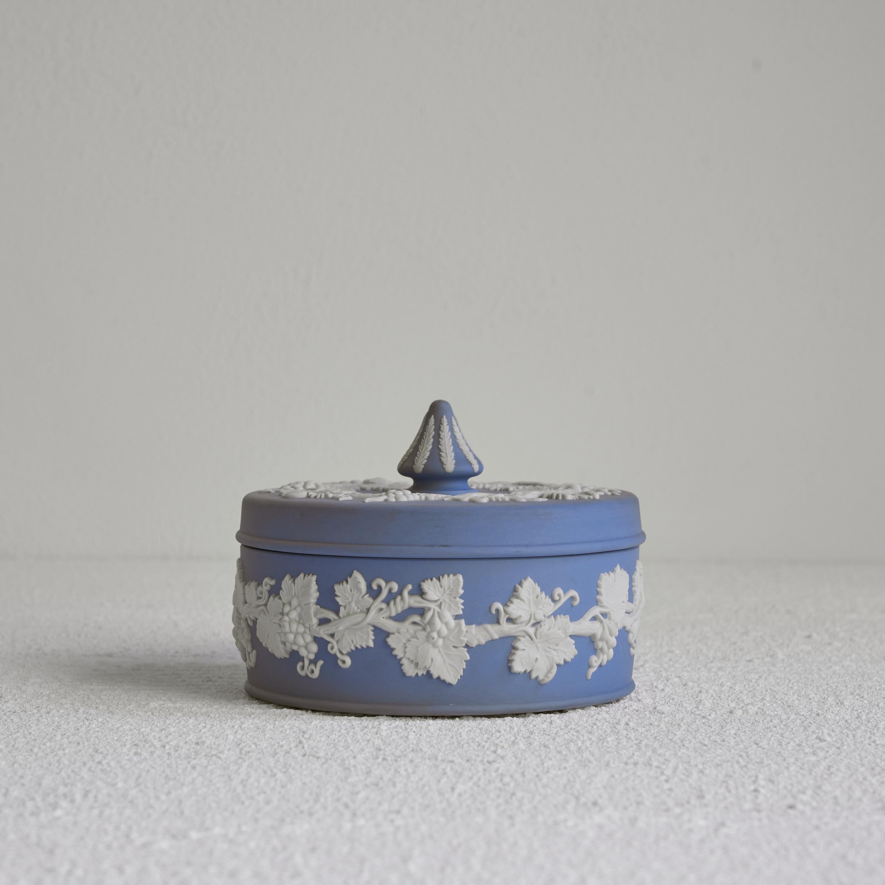 Wedgwood Jasperware Lidded box, England, 20th century.

This is a quintessential piece of Wedgwood Jasperware. Lidded box in the famous Jasperware blue and white decor. Neo-classical and elegant. Please note the beautiful white decoration with