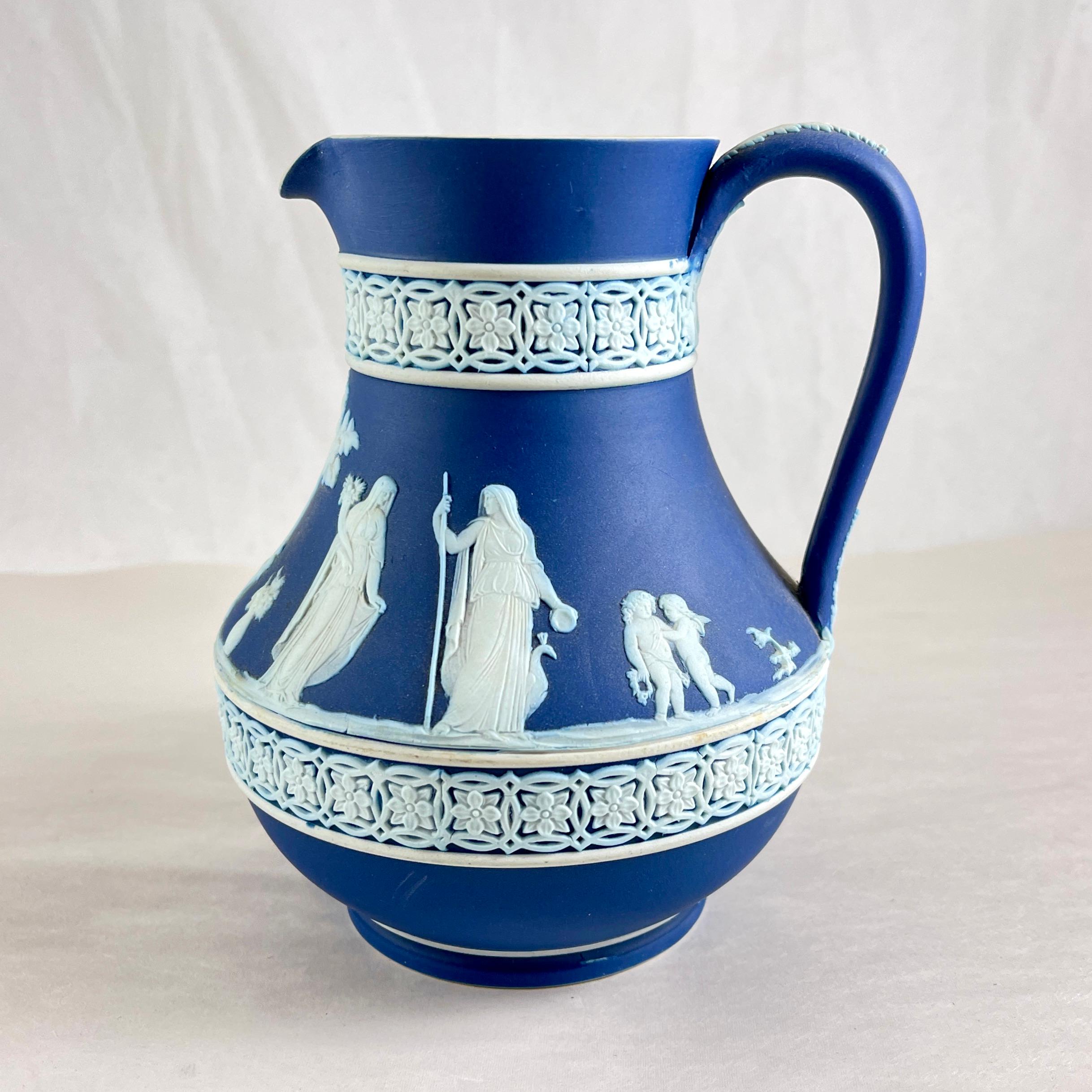 Da Wedgwood, una brocca in stile neoclassico di colore blu intenso, con forma e motivo etrusco, datata 1930.

Decorazione figurata a rametti bianchi applicata su un fondo blu intenso. La brocca è bordata vicino alla base e al collo con un motivo