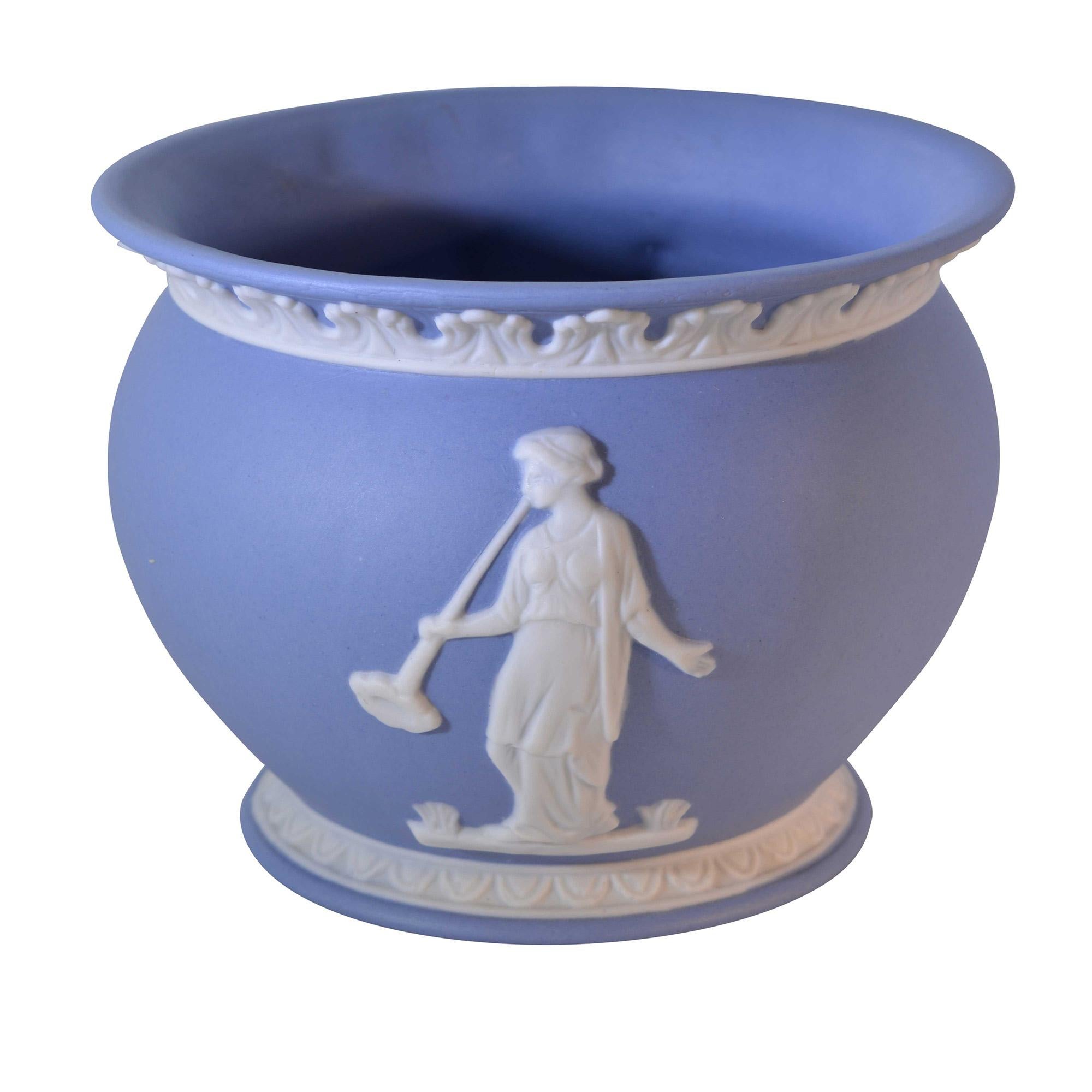 There is something about Wedgewood Jasperware that is so appealing. The soft blue base with the ivory white detail is just so elegant. This vase has a detailed rim and both front and back have raised detail depicting Grecian goddess. 

Dimensions: