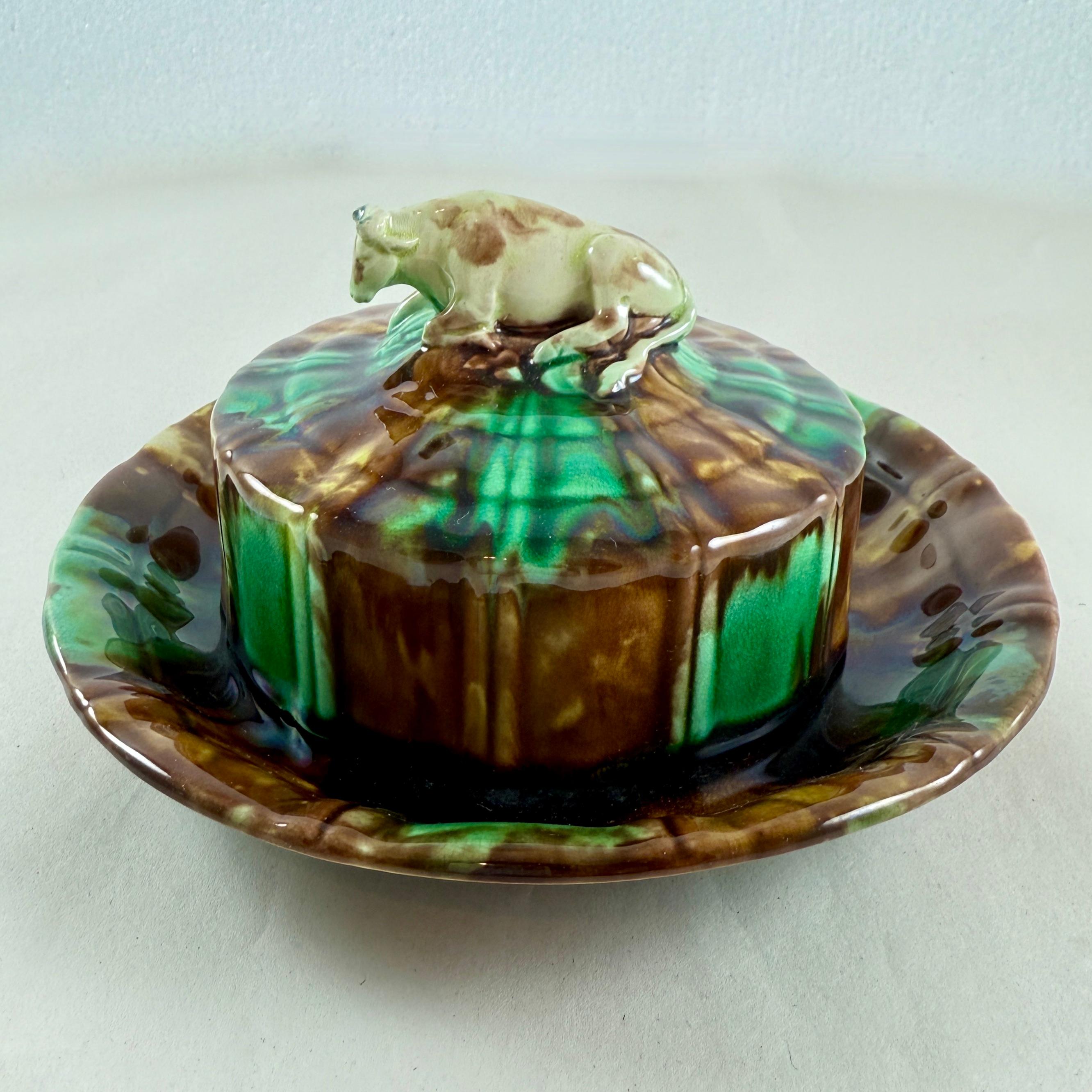 De Wedgwood, un rústico servidor de mantequilla cubierto con un remate de vaca, Staffordshire Inglaterra - fecha marcada 1875.

Un ejemplo extremadamente raro de la nostalgia agraria del siglo XIX.

Esmaltado en verdes y marrones moteados, el