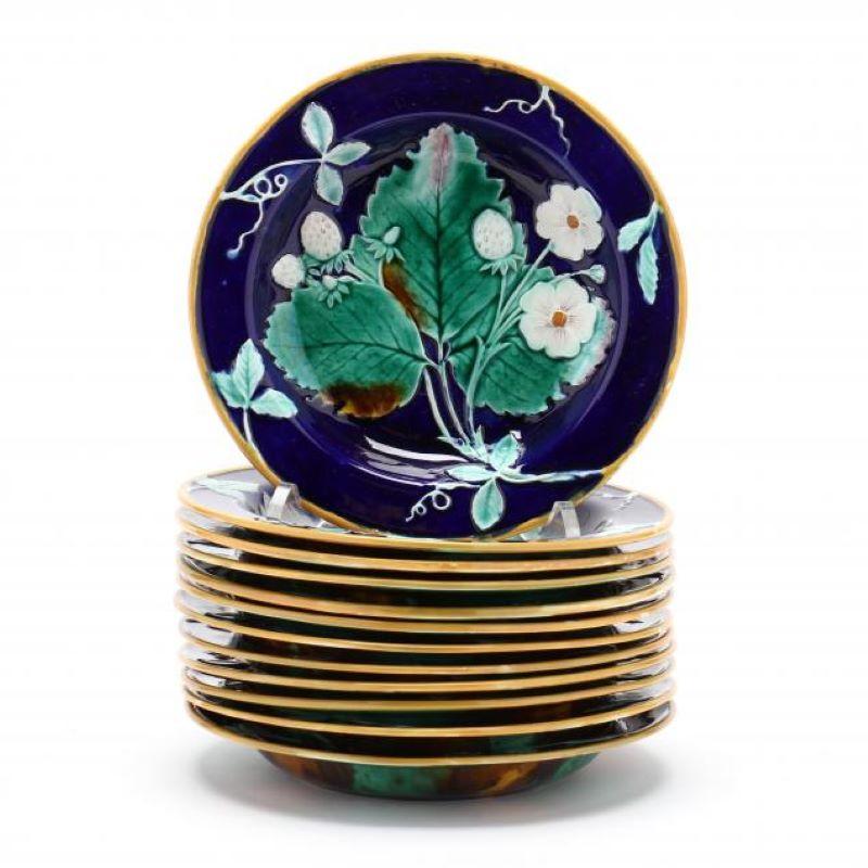 Piatto in maiolica di Wedgwood con fragole, foglie e fiori in rilievo, labbro con foglie e viticci di fragola, bordo smaltato di giallo, fondo blu cobalto, rovescio smaltato a chiazze blu, verdi e marroni, con marchi impressi 