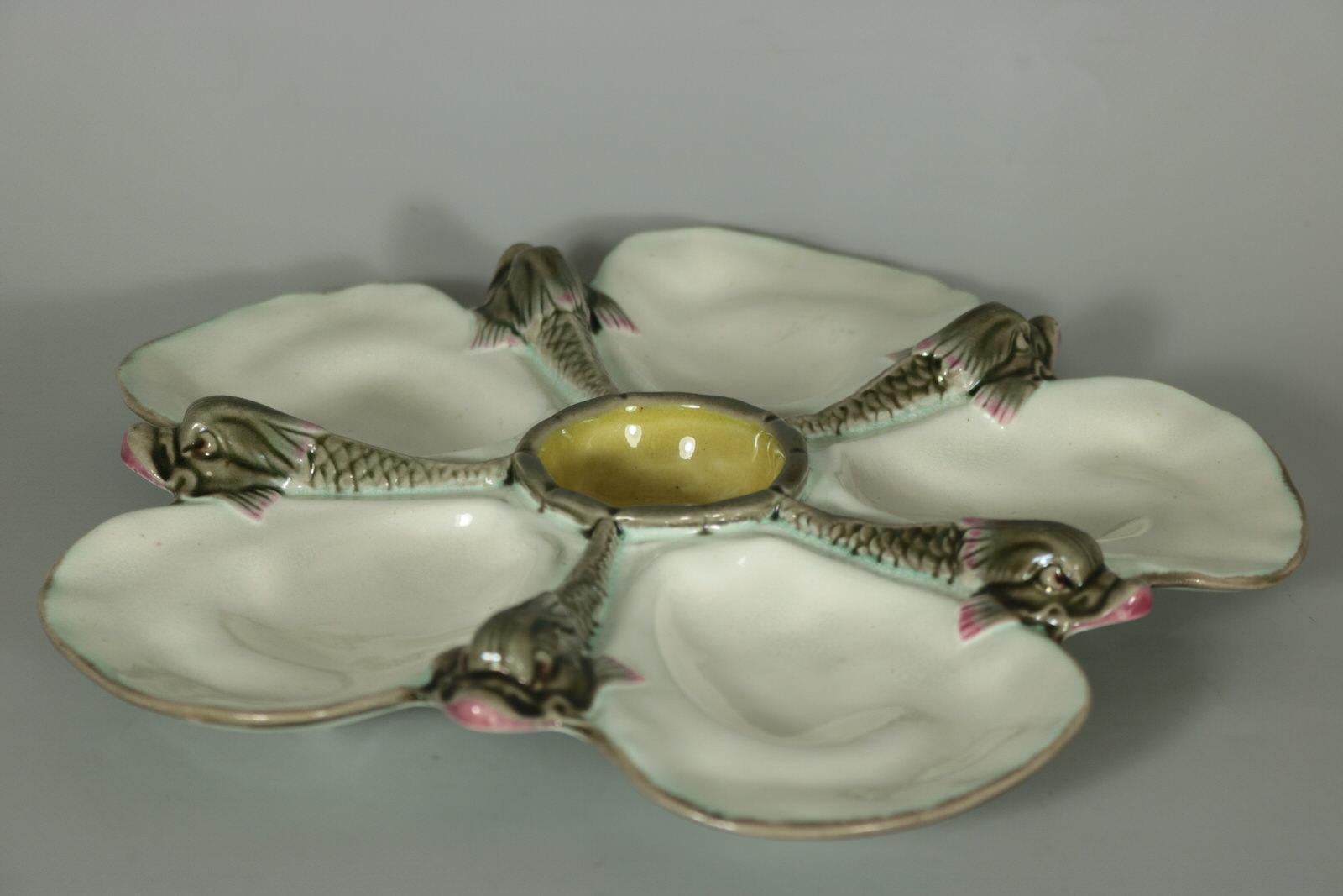 Wedgwood Majolica oyster plate which features five fish around a central well. White ground version. Colouration: white, grey, yellow, are predominant. The piece bears maker's marks for the Wedgwood pottery. Bears a pattern number, '2754'. Marks