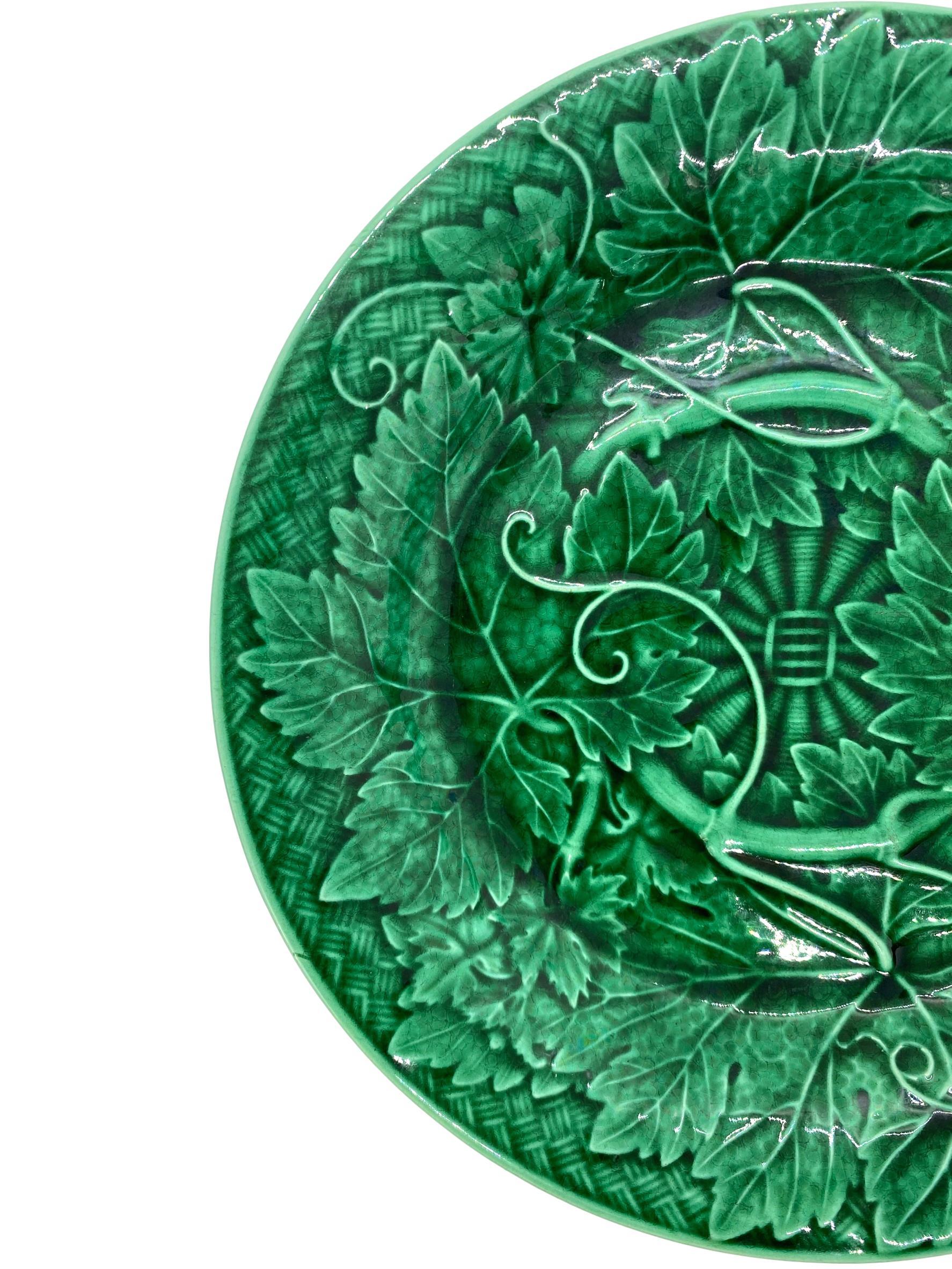 Wedgwood Majolica green glazed plate, with relief-molded grape leaves and vines, raised on a basketweave ground, the reverse with impressed mark 'WEDGWOOD' and date letter 'O' for 1885.

For 30 years we have been among the world's preeminent