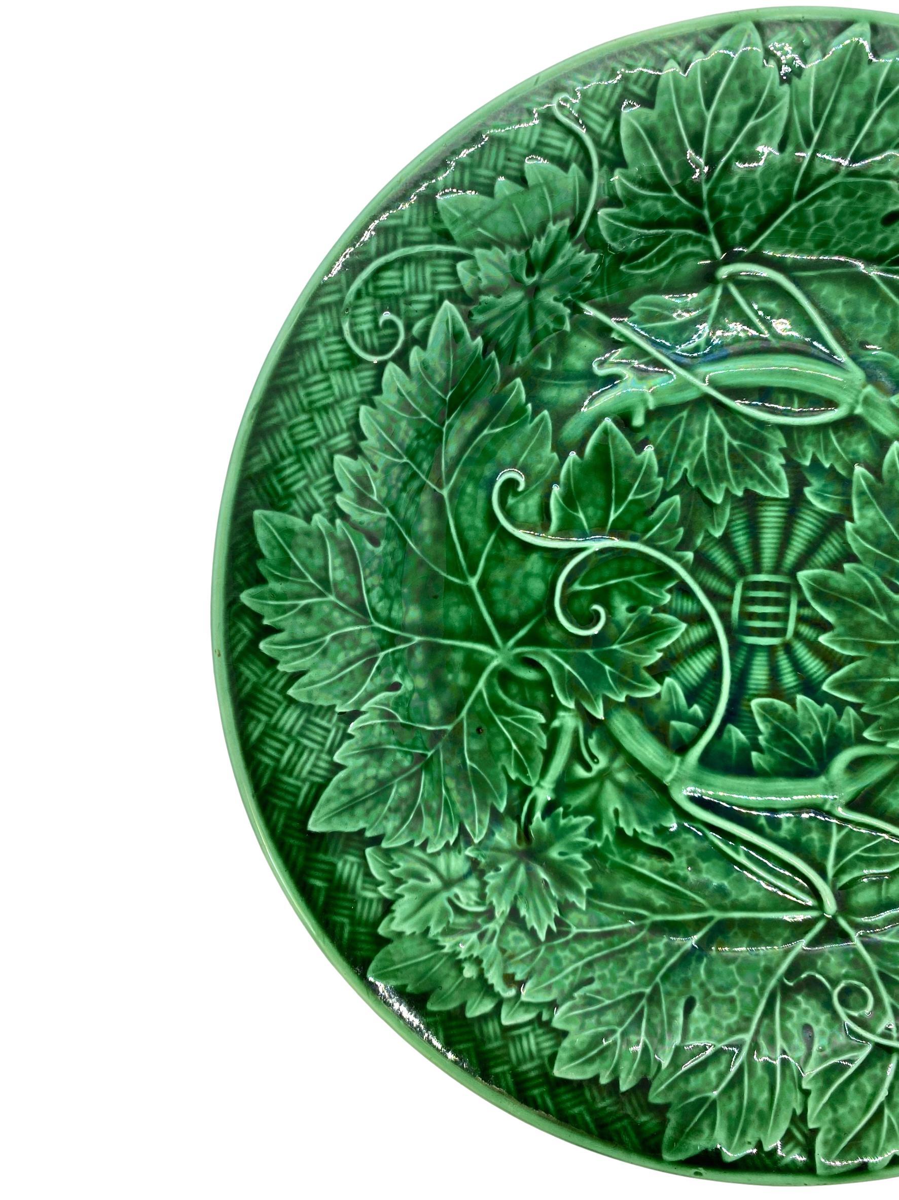 Wedgwood Majolica green glazed plate, with relief-molded grape leaves and vines, raised on a basketweave ground, the reverse with impressed mark 'WEDGWOOD' and date letter 'W' for 1894.

For 30 years we have been among the world's preeminent