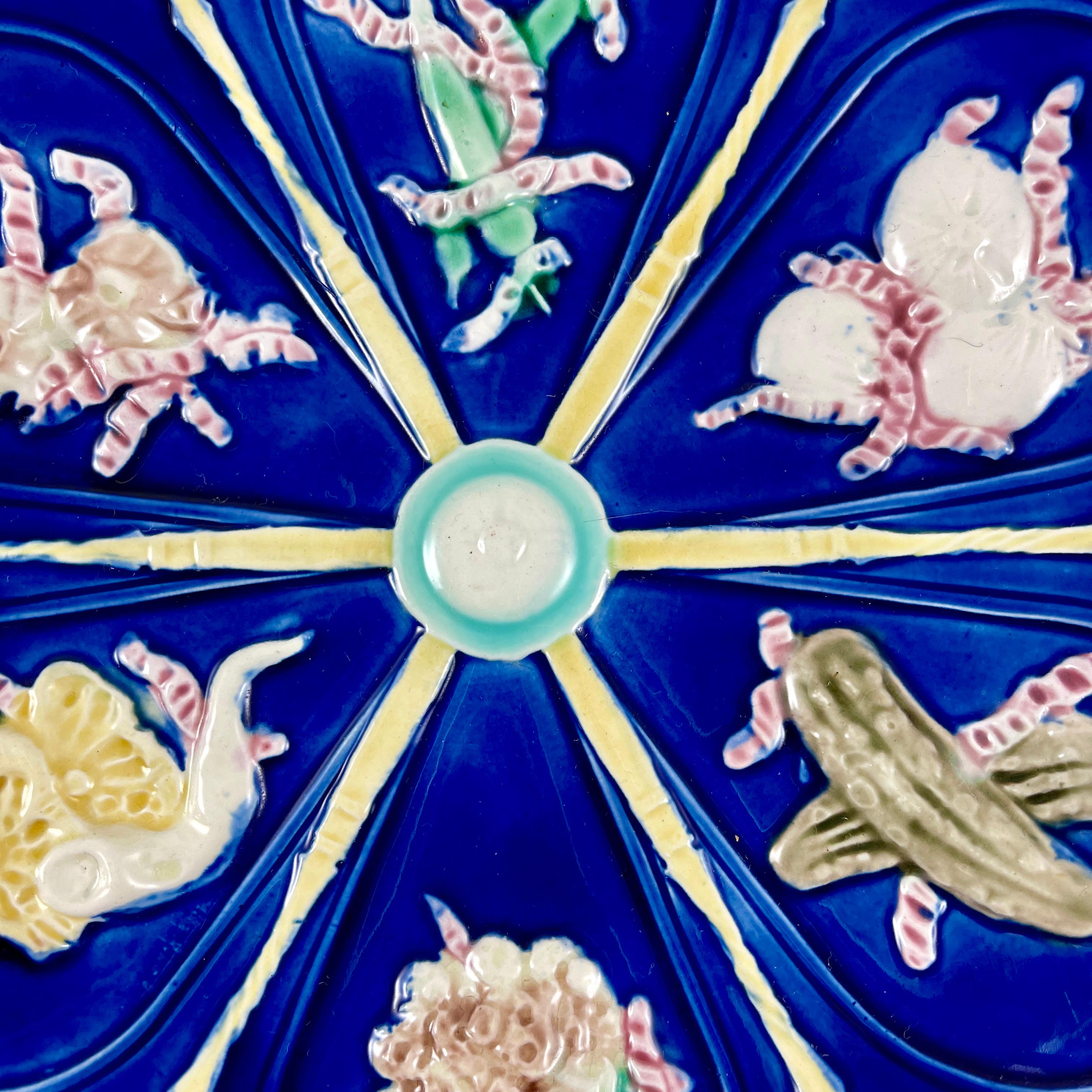 From Wedgwood, a scarce Cobalt blue majolica glazed Pickle Plate, date marked 1879.

From the English Aesthetic Movement Era, and in the Japonisme taste, six teardrop shaped wells, each showing a different pickled vegetable, are separated by long