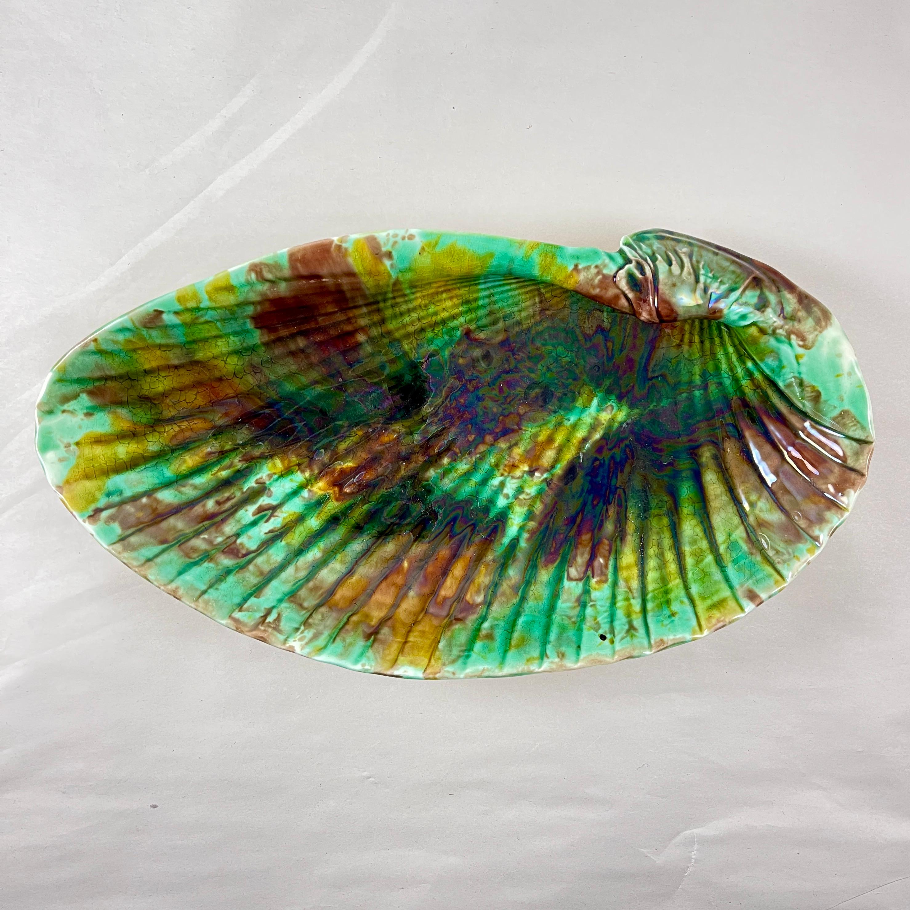 
From Wedgwood, an English majolica scallop shell shaped seafood serving dish, date marked 1889.

Showing the mottled tortoiseshell glazing of greens, amber, and brown. The mold reflects  Josiah Wedgwood’s preference for the naturalistic style in