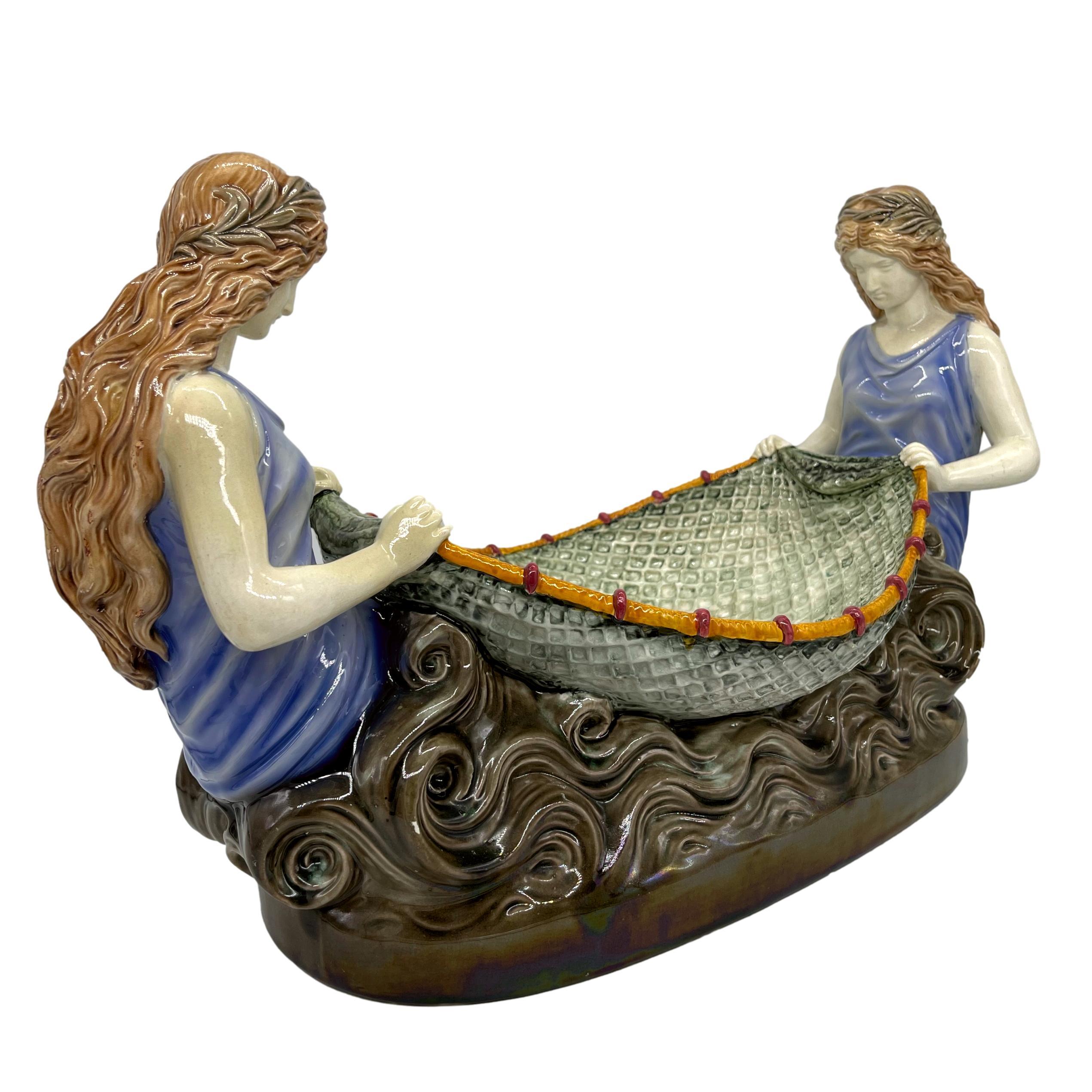 Wedgwood Majolica Figural Centerpiece, modelled as two pre-Raphaelite naiads with a fishing net forming the bowl, in simulated waves, the reverse with impressed marks: 'WEDGWOOD,' and date letters 'DEK' for December 1882. The design number, 797,
