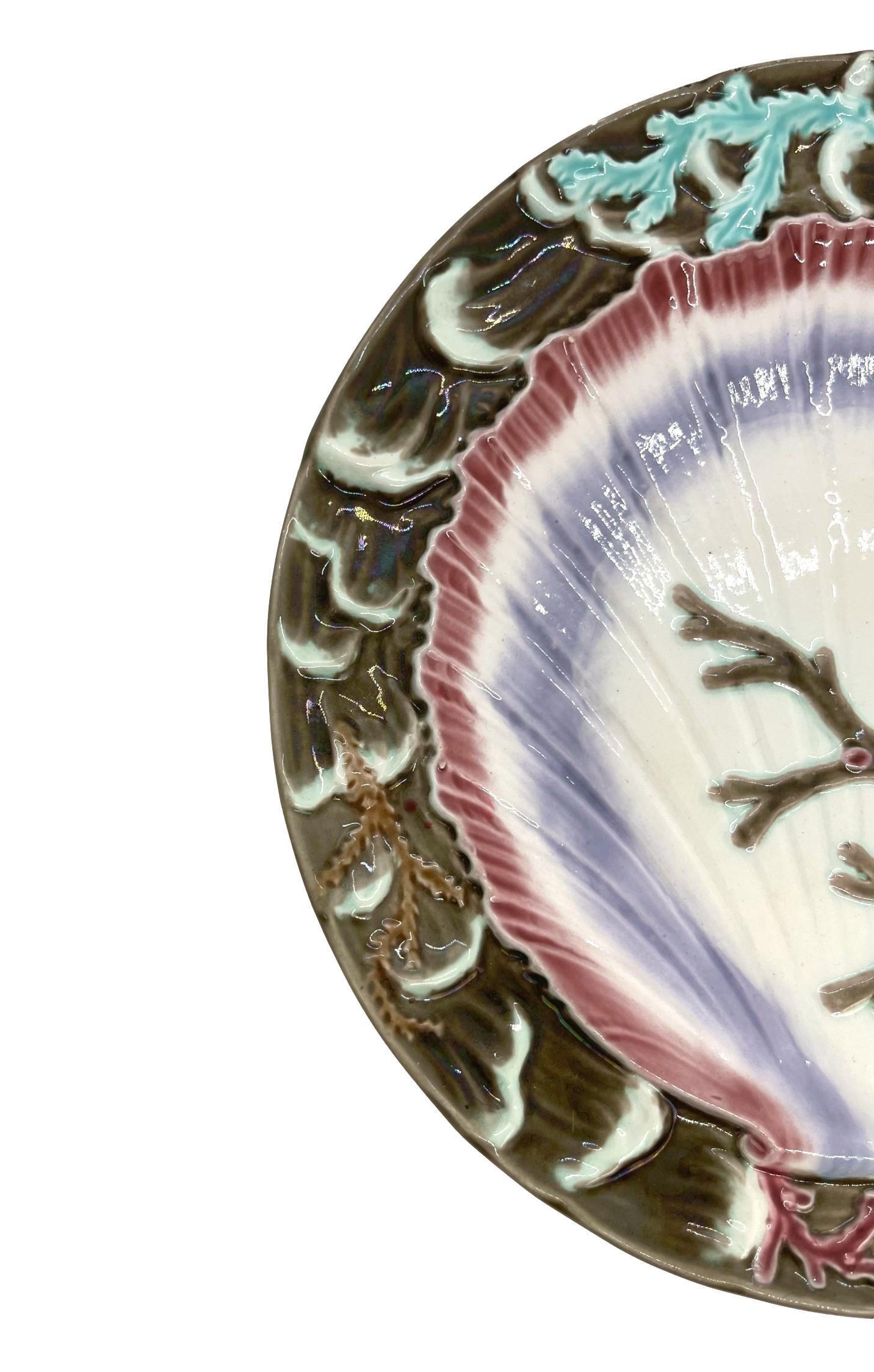 Wedgwood Majolica ocean plate, with a large central shell and seaweed, bordered with relief-molded waves, the reverse with impressed marks: 'Wedgwood,' and Wedgwood date letter, 'N' for 1885, with underglaze painted design number, '2934,' which