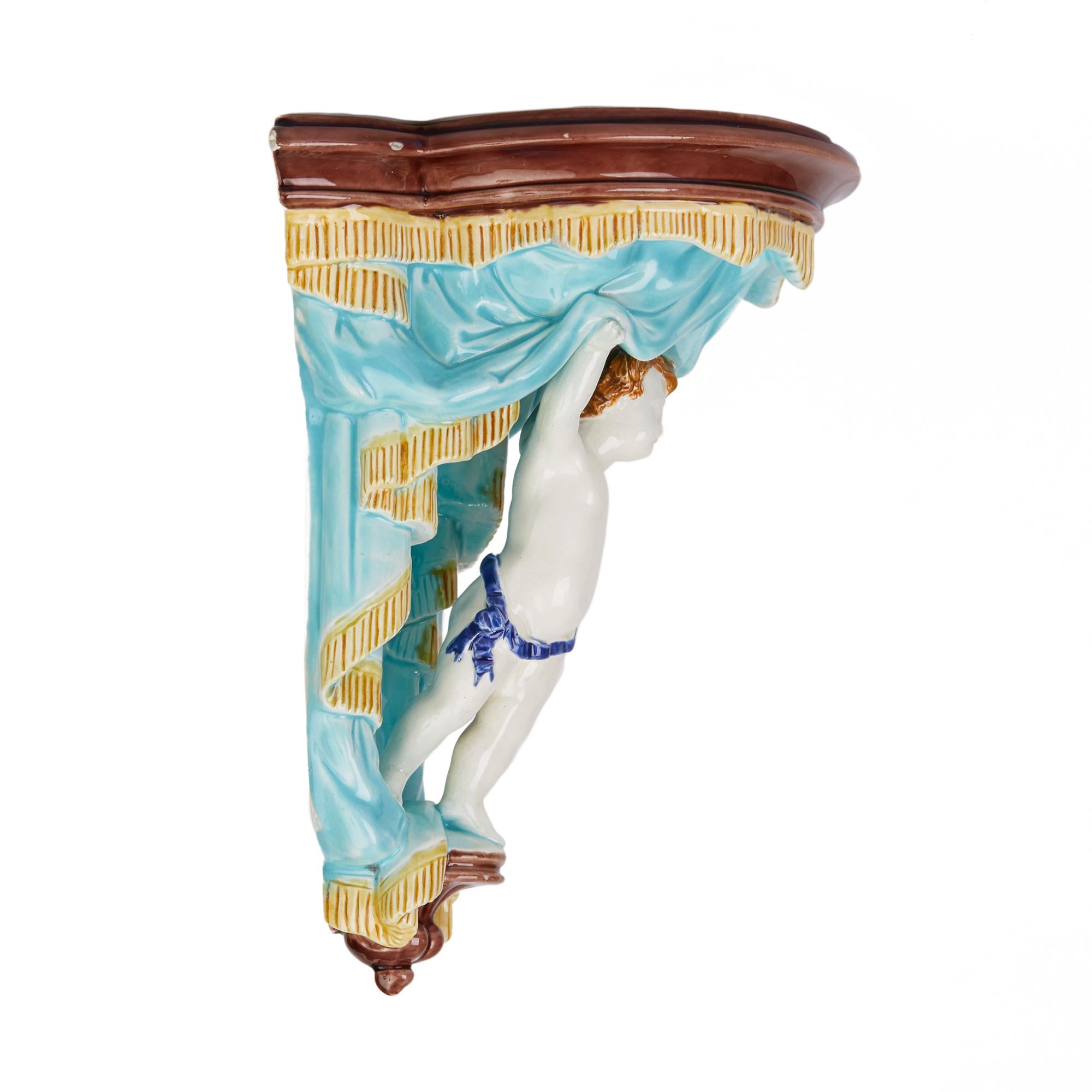 A rare and unusual antique Wedgwood Majolica pottery wall bracket dated 1872. The heavily made bracket portrays a young body standing on a narrow pedestal base supporting and lifting a curtain with tasseled edge below and edged overhang forming the