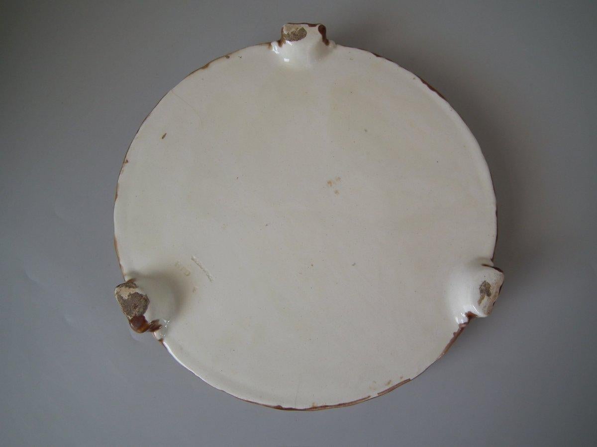 Wedgwood Majolica cheese keep which features yellow primroses and a basket weave border. Cobalt blue ground version. Colouration: green, ochre, brown, are predominant. The piece bears maker's marks for the Wedgwood pottery. Marks include a factory
