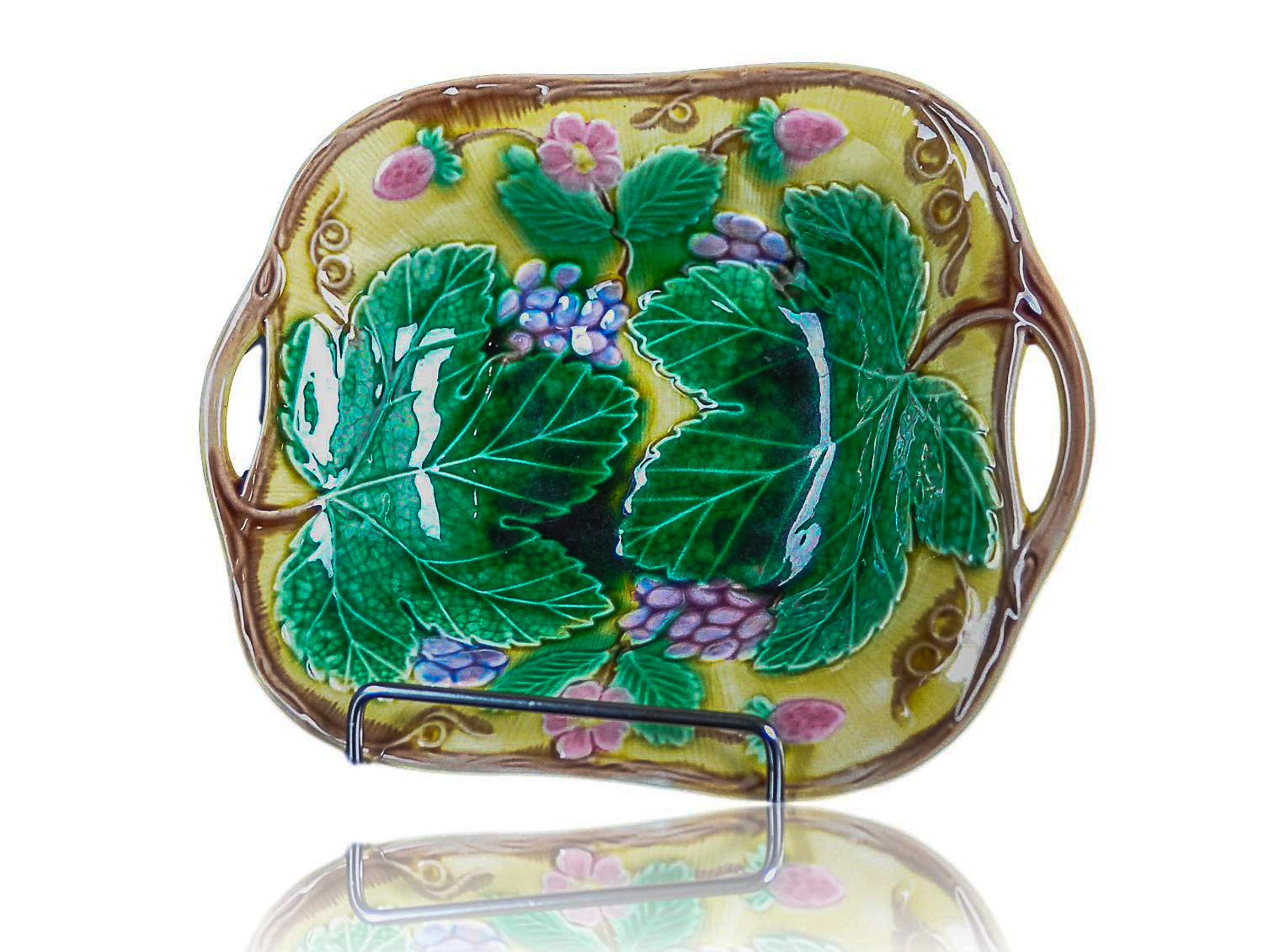 Wedgwood Majolica 'Vine & Strawberry' Dish, English, Dated 1940, with a large central green grape leaf, purple grapes, reddish pink strawberries and blossoms on a deep yellow ground. Marks to reverse: 'WEDGWOOD' Seal and impressed with the
